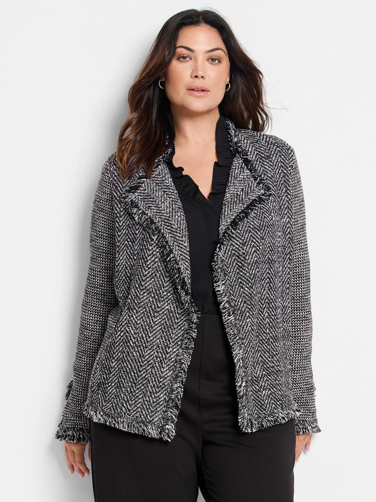 Black & white mix knit jacket with fringe on the lapels, hem, and cuffs.