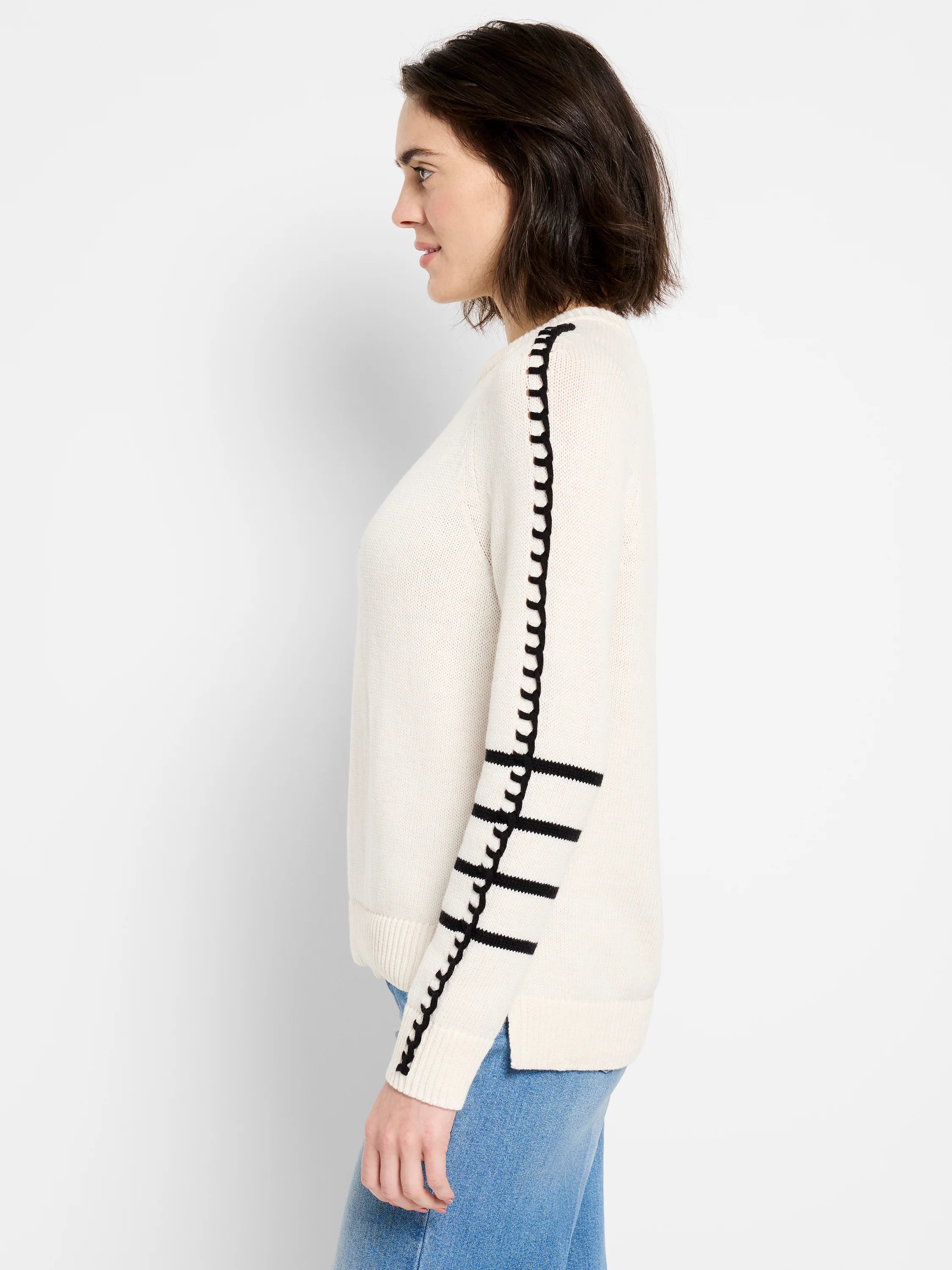 Cream sweater with black wavy stripe down arm and two black horizontal stripes above cuff.