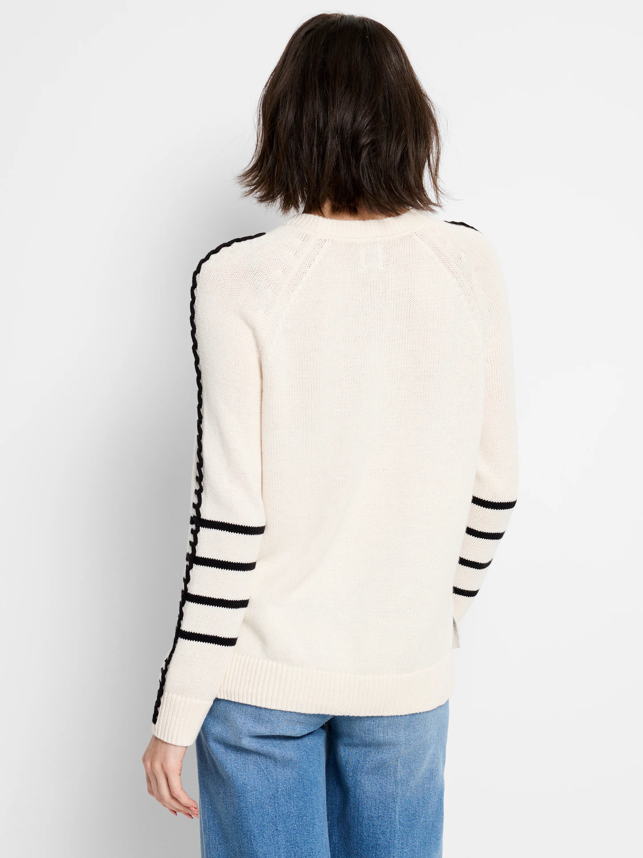 Off-white crewneck sweater with black braided stripe on outer arms and three black horizontal bands on forearms.