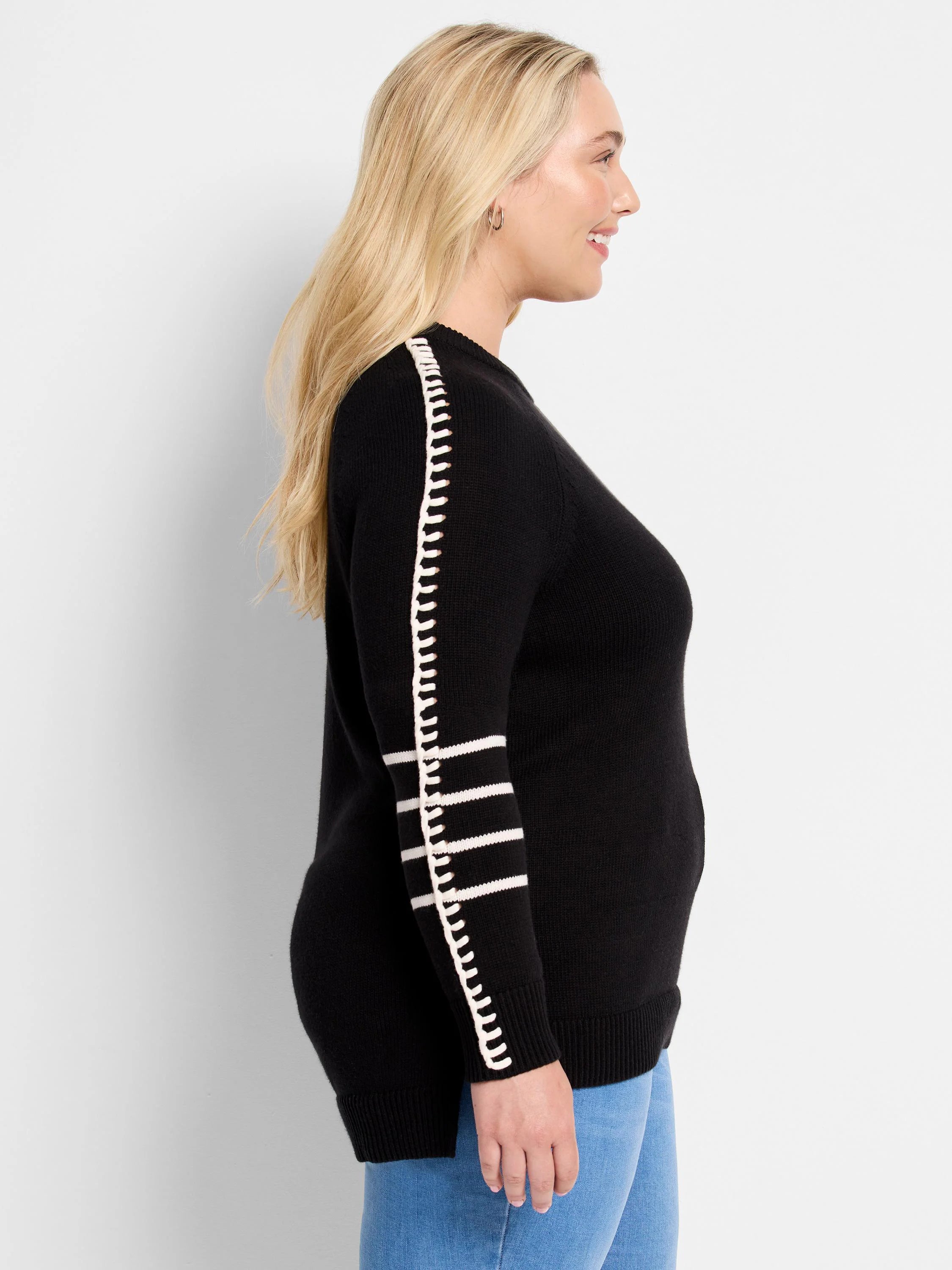 Black sweater with a white decorative vertical stripe on the outer arm, and three horizontal white stripes on the lower...
