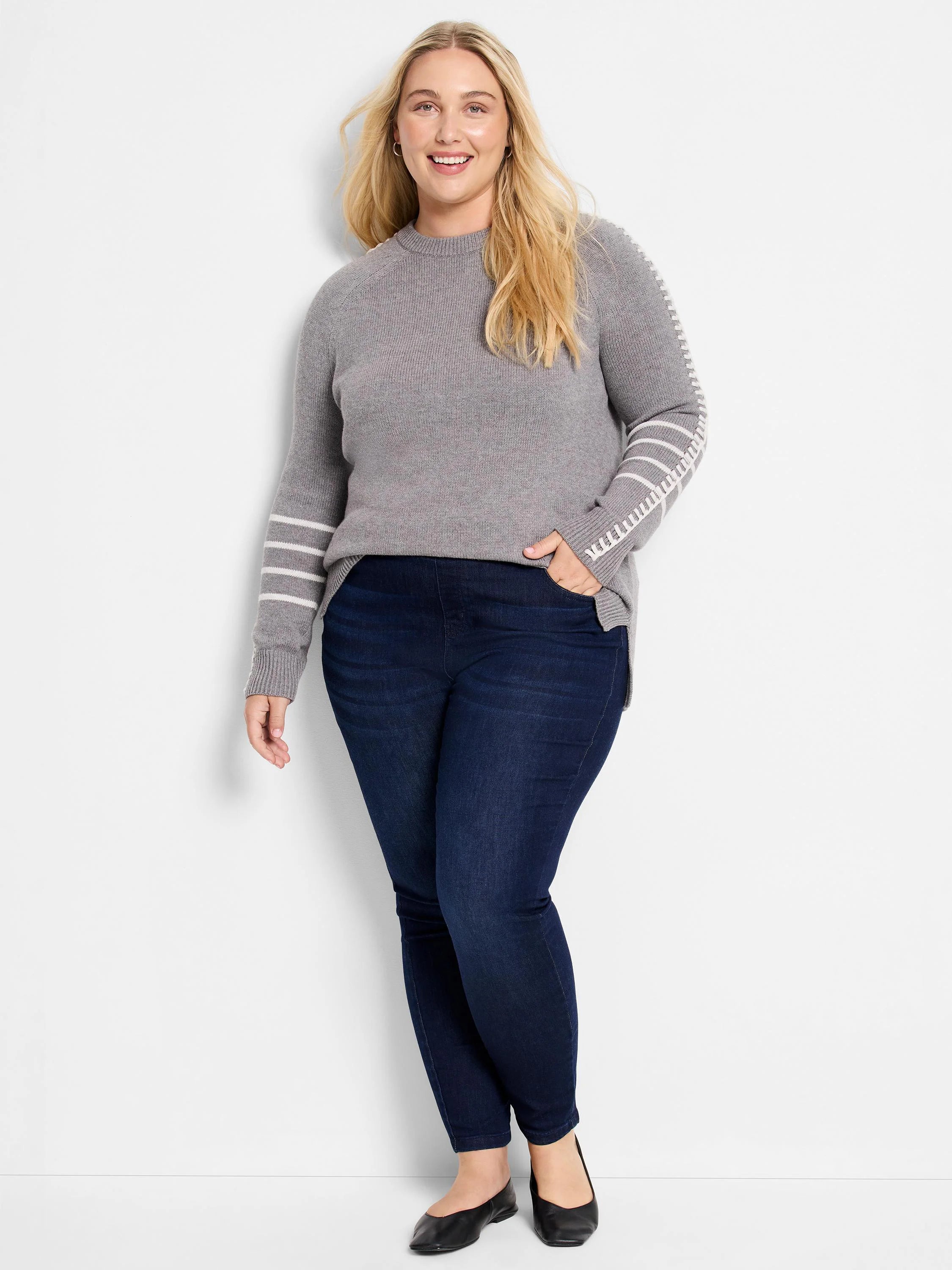 Grey crew neck sweater with white horizontal stripes and a white stitch pattern on sleeves.