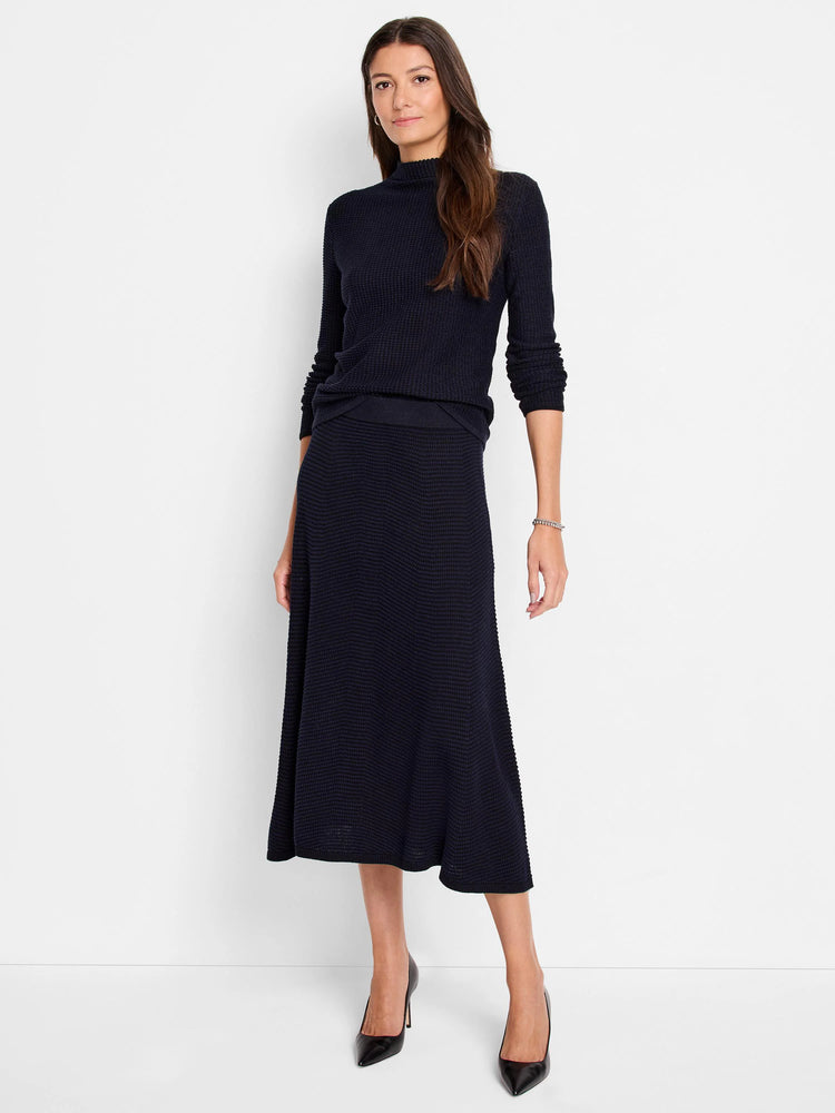 Dark navy pixel knit mock neck sweater with long sleeves, worn with a matching midi skirt featuring the same textured knit.