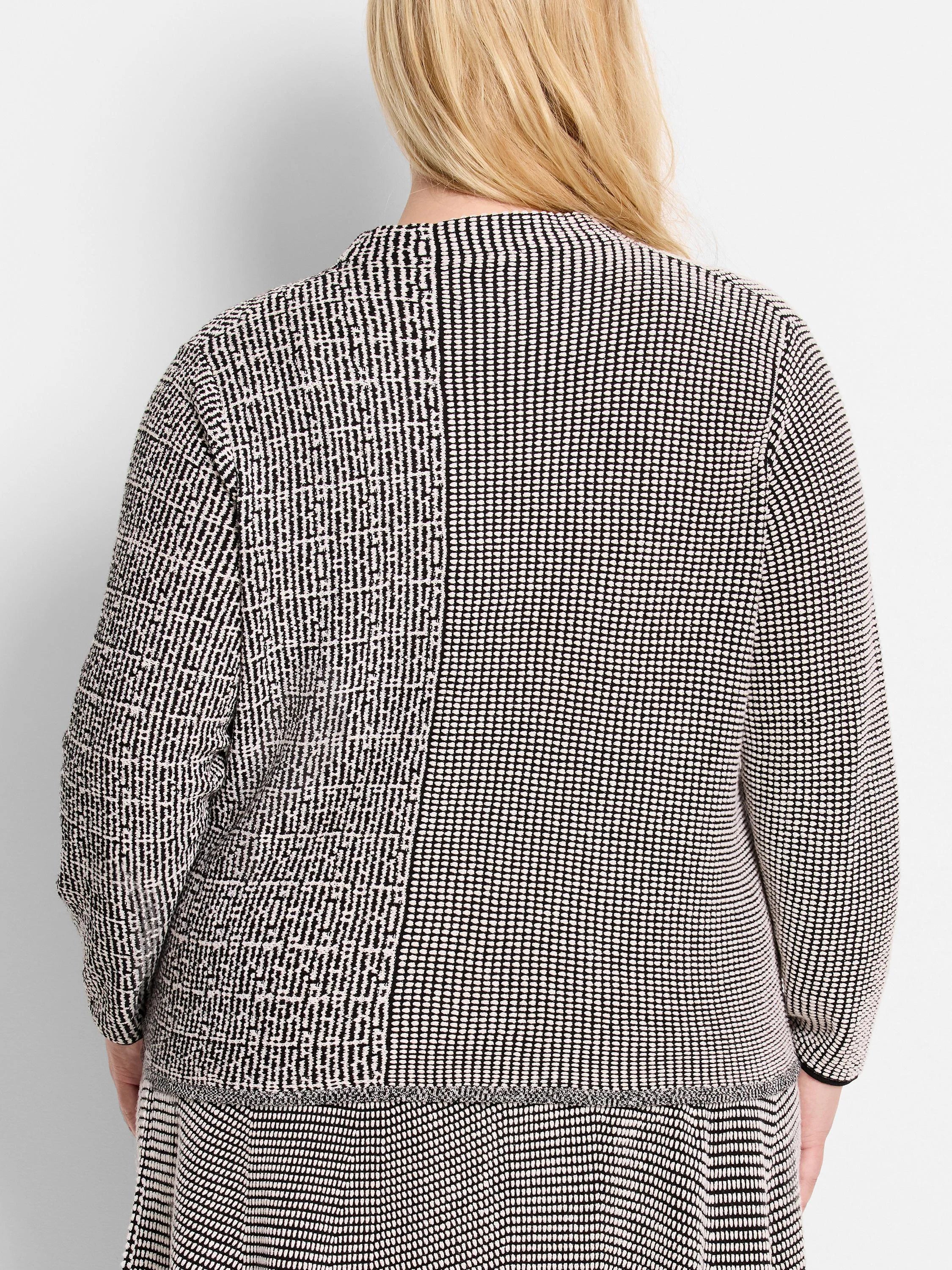 Black and off-white knit sweater. Two-toned geometric pattern; back view shows a slightly flared hem.