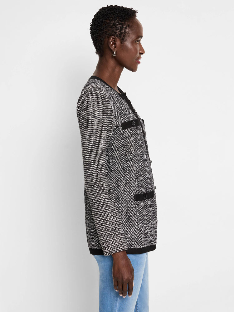 Black and white herringbone knit jacket with black buttons and trim. Side profile view.