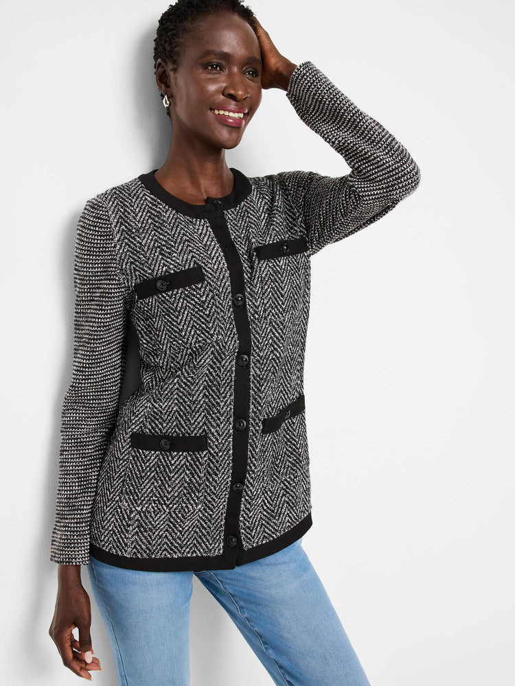 Black & white herringbone knit jacket with black trim, button front, and patch pockets. Long sleeves, textured knit.