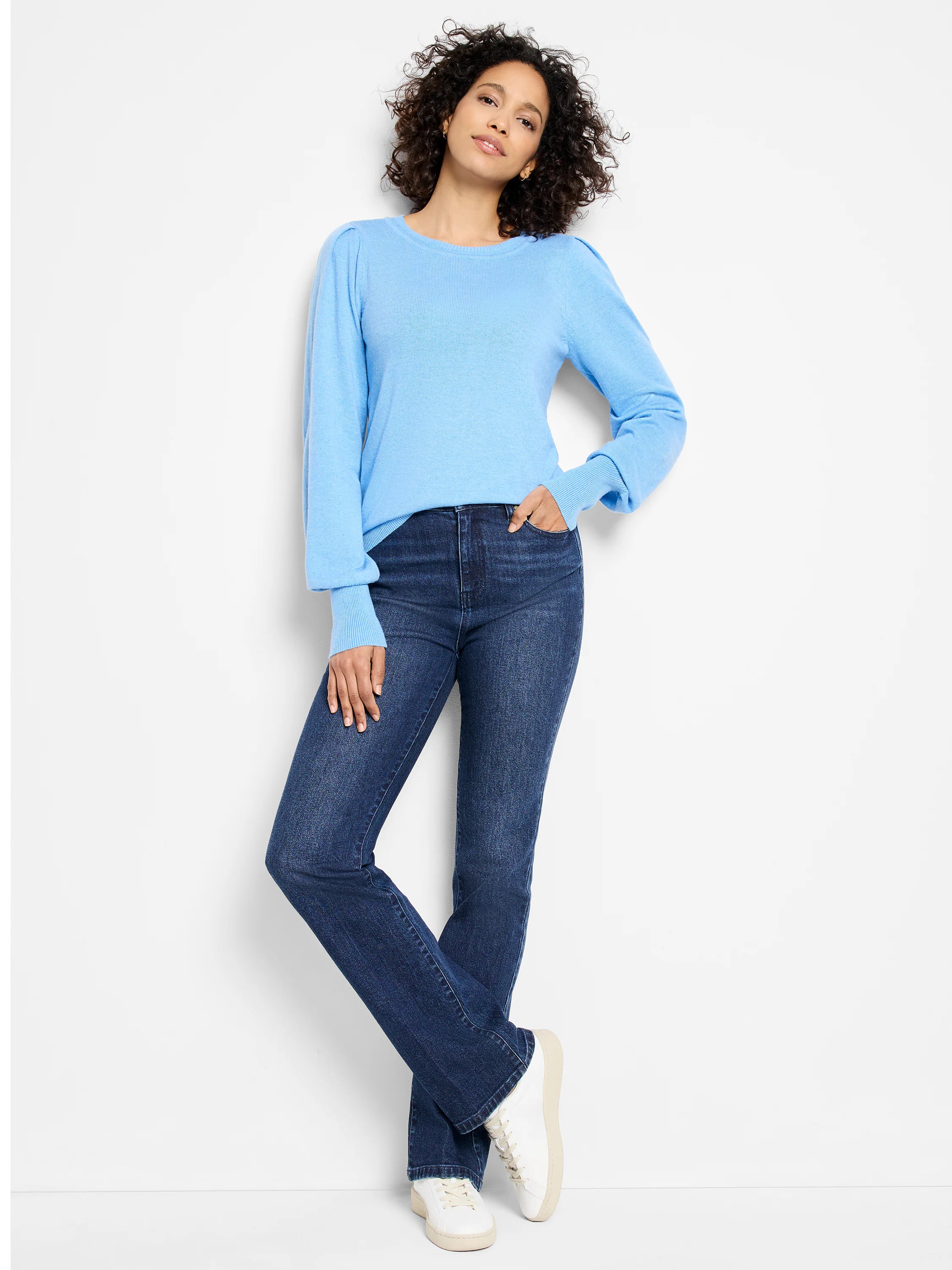 Light blue knit sweater with a round neck, puffed sleeves at shoulders, and ribbed cuffs.