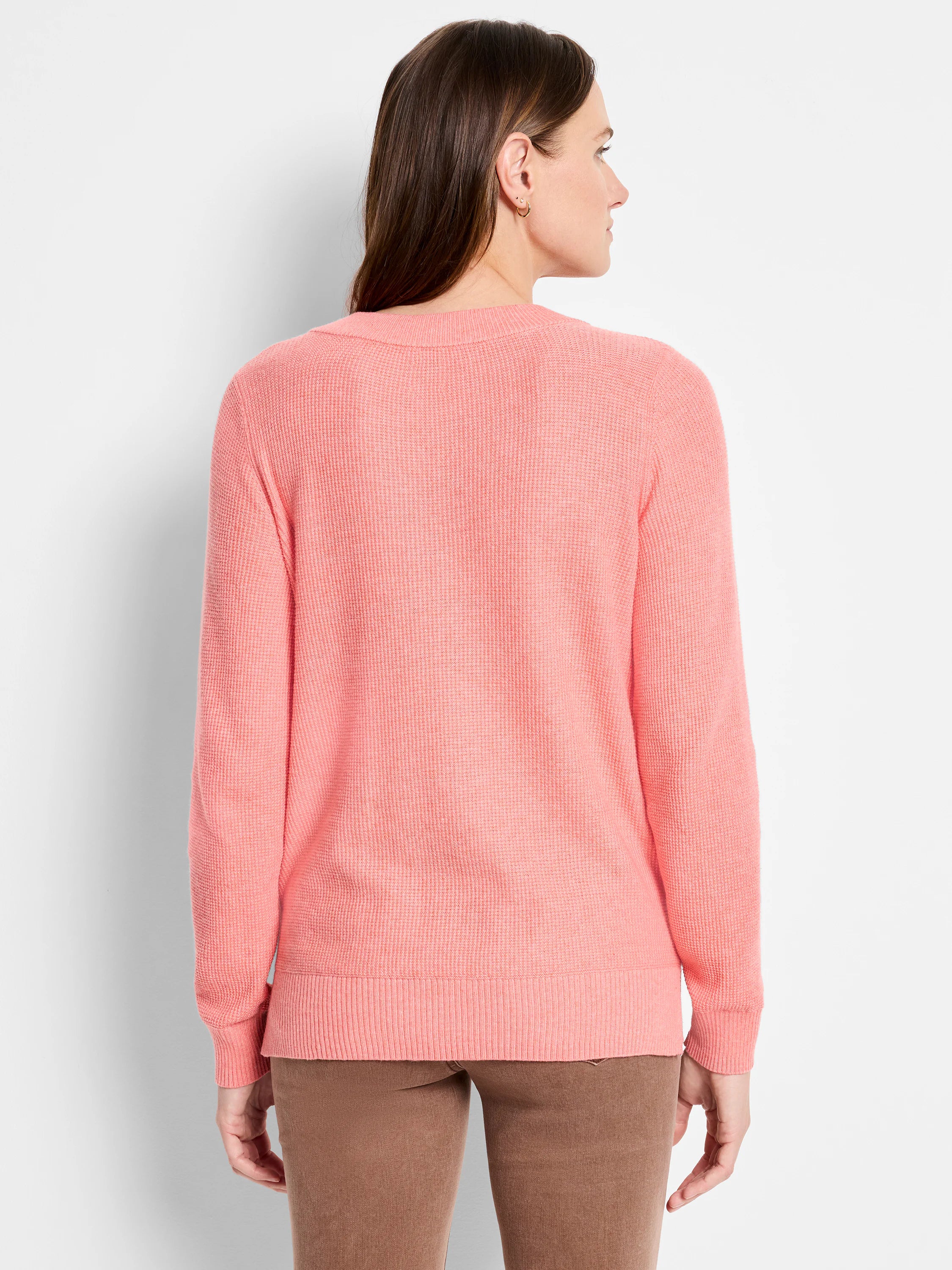 Coral waffle-knit sweater, back view. Features textured stitch on body and long sleeves.