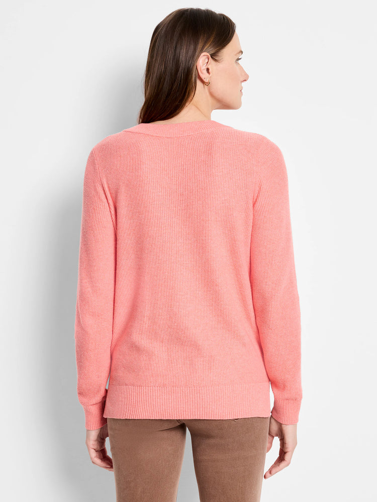 Coral waffle-knit sweater, back view. Features textured stitch on body and long sleeves.