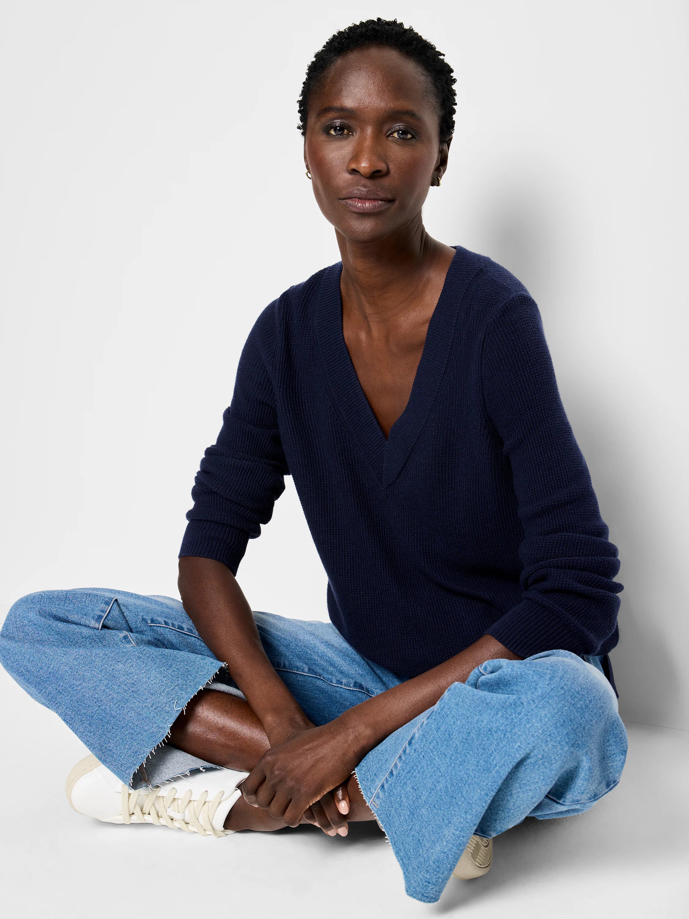 Navy blue long-sleeve V-neck sweater with visible waffle stitch, worn by a model.