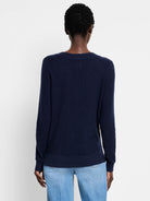 Navy blue waffle-knit sweater, shown from the back. Features long sleeves and a ribbed back collar.