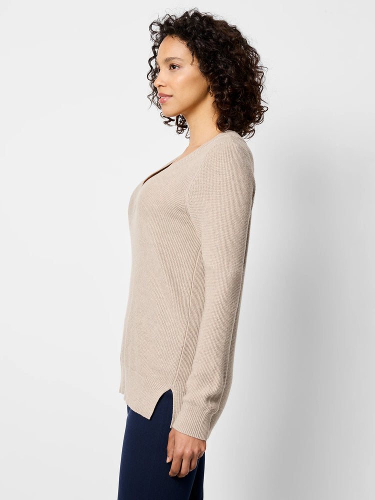 Light beige waffle stitch V-neck sweater, with long sleeves and side slits at the hem.
