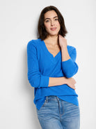 Bright blue V-neck sweater with waffle-textured knit, long sleeves, and ribbed cuffs.