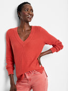 A red-orange waffle stitch V-neck sweater.