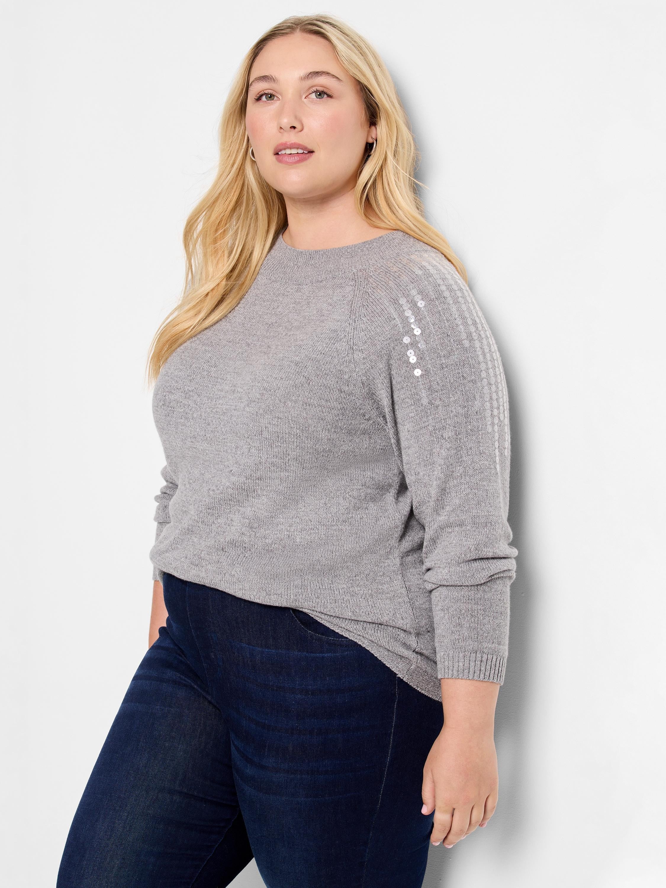 Gray sweater with long sleeves and silver sequins on the upper arms. Crew neck.