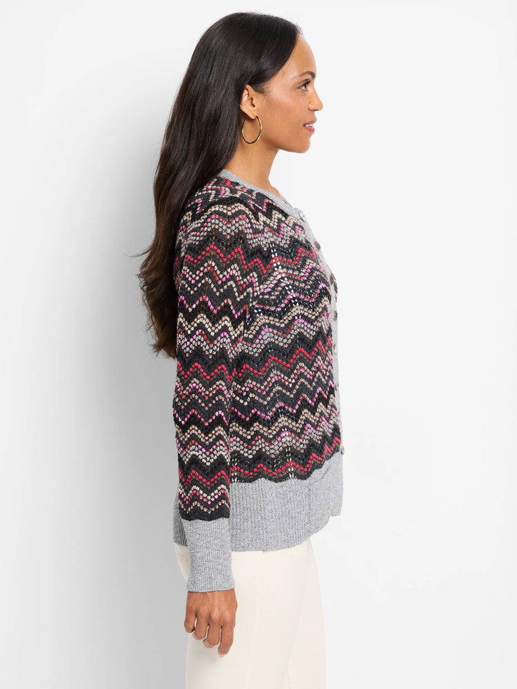 Zigzag patterned cardigan. Black base with pink, beige, and grey accents. Grey ribbed hem and cuffs. Button front.