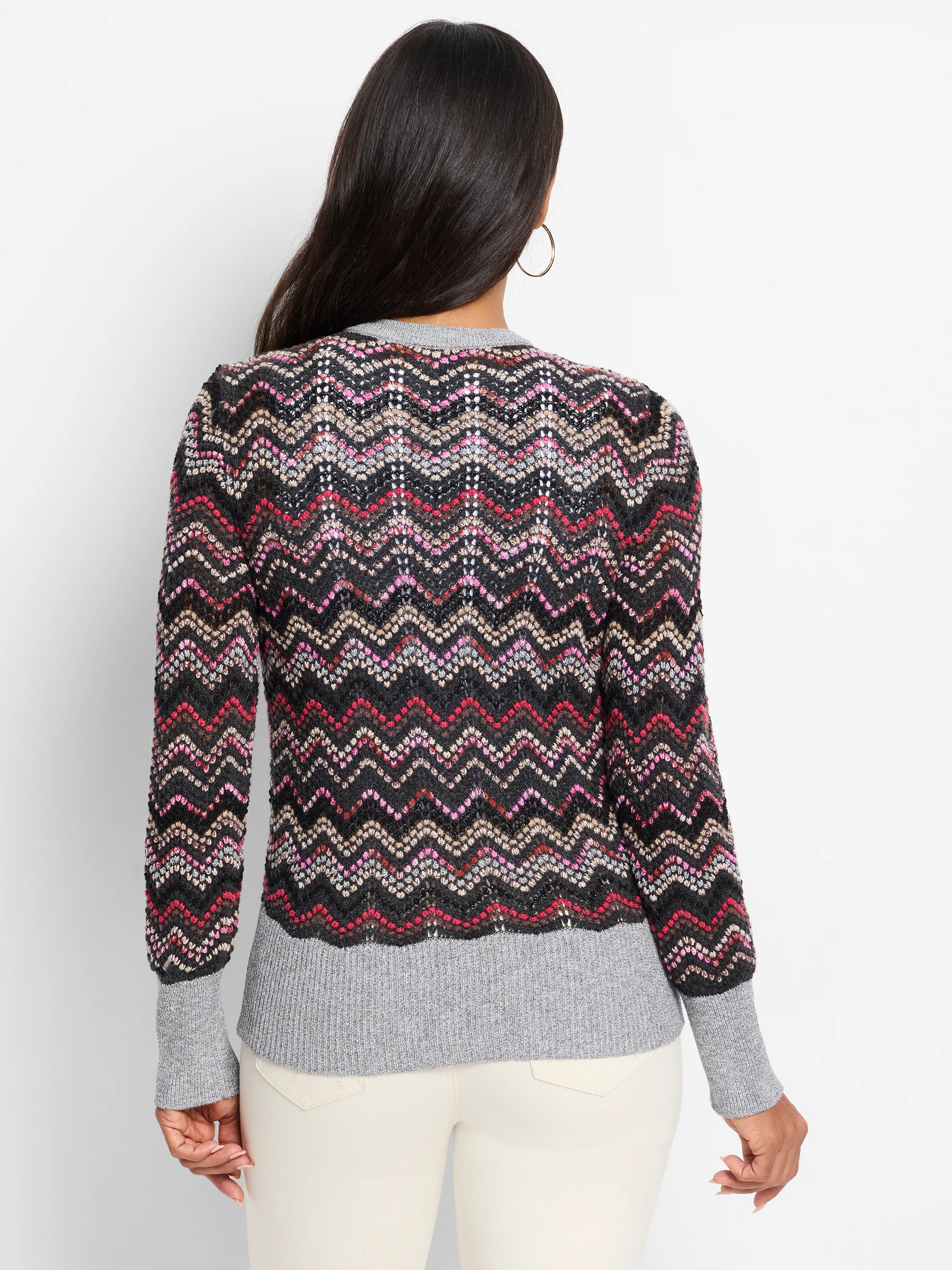 Zigzag patterned cardigan. Primarily black with pink, beige, and gray wavy stripes. Gray ribbed cuffs and hem.