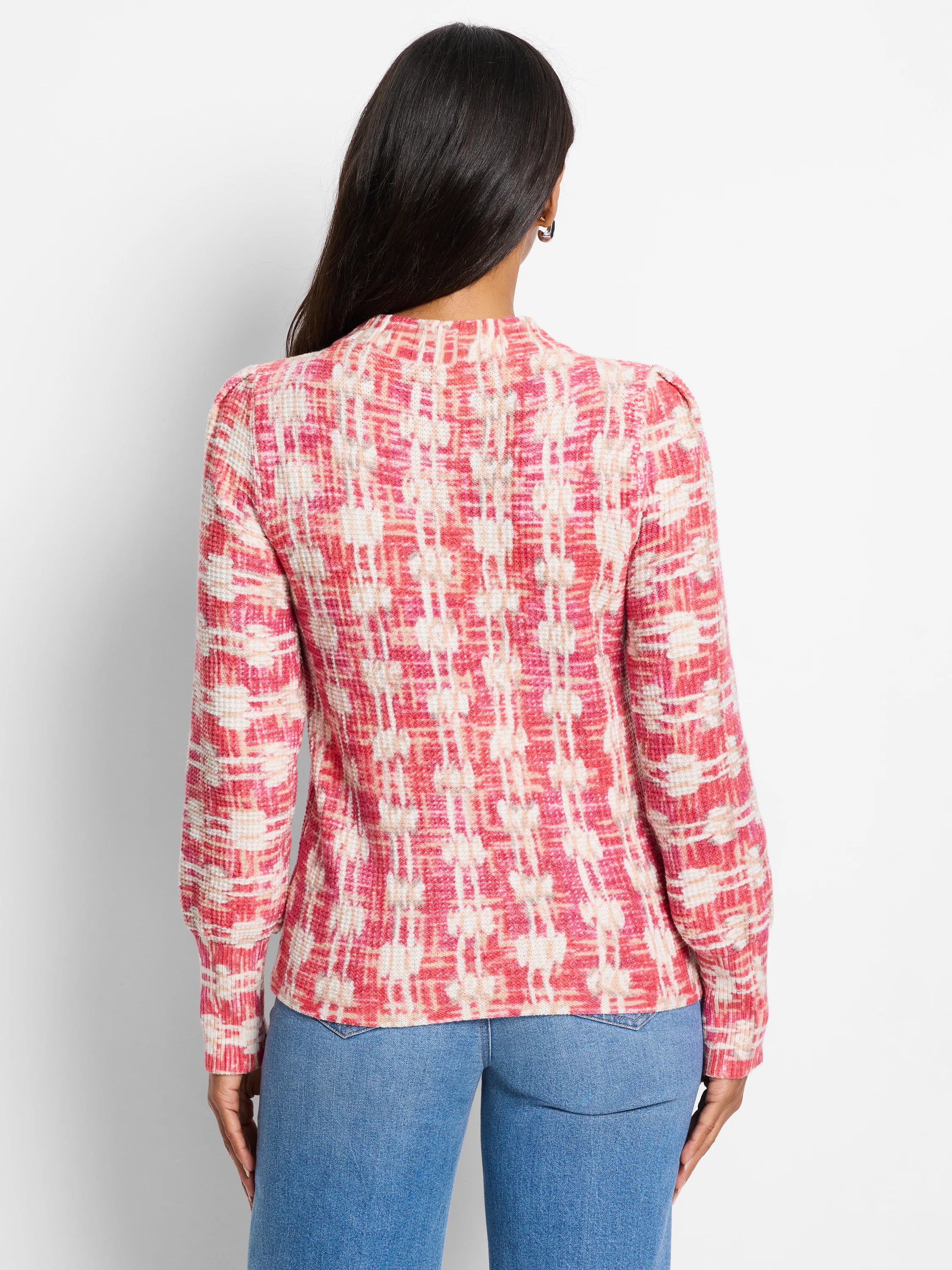 Red, pink, and cream waffle-knit sweater. Abstract pattern. Long sleeves. Back view.