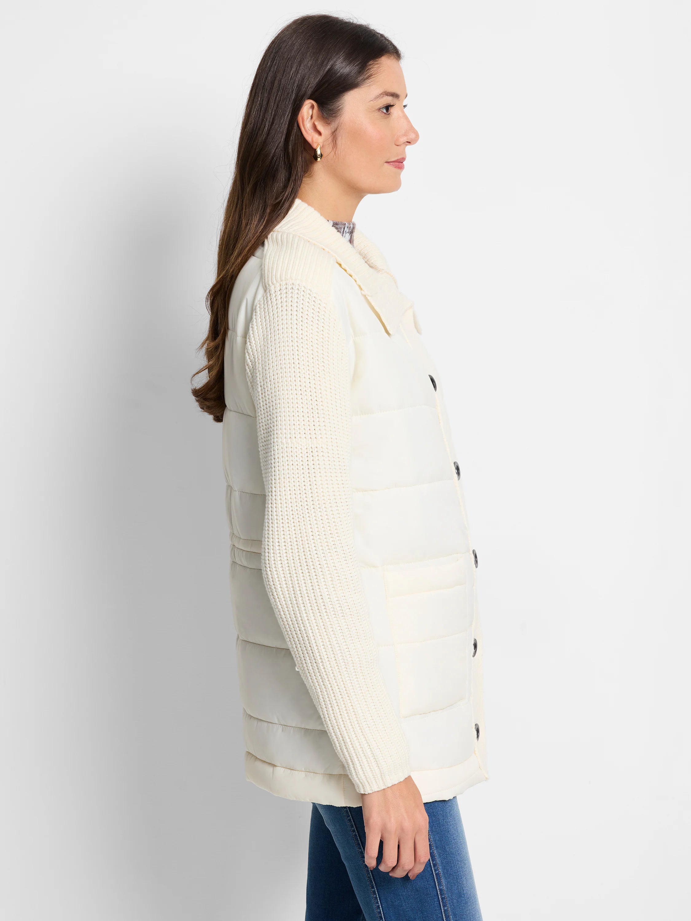 Off-white quilted puffer jacket with off-white knit sleeves and dark buttons. Side view.