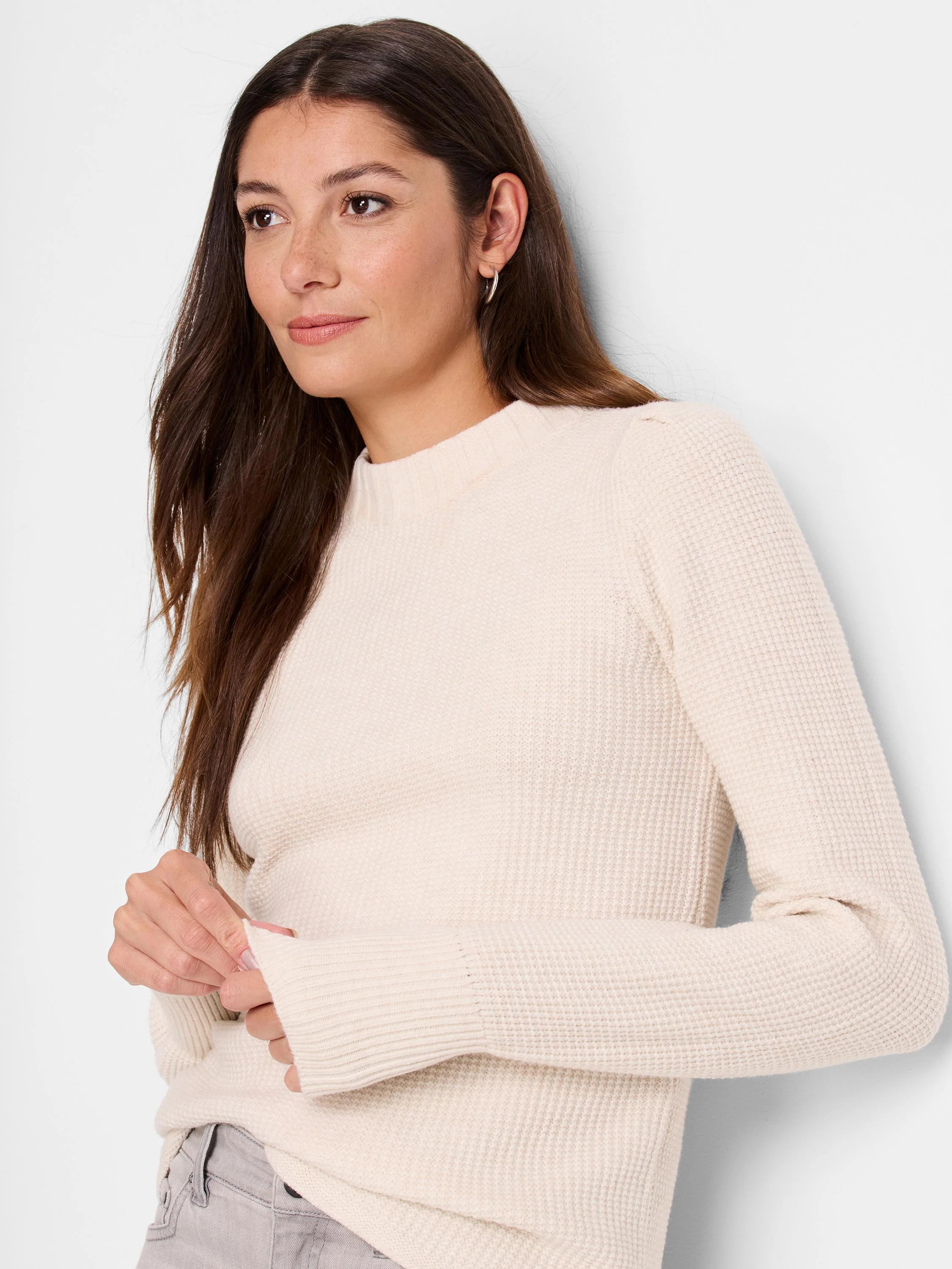 Off-white waffle-knit sweater, long sleeves, crew neck. Textured fabric.