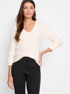 Cream V-neck sweater with baby garter knit texture and ribbed cuffs.