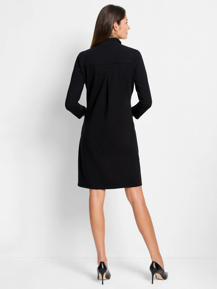 Black, knee-length dress. Mock turtleneck, 3/4 sleeves, slightly A-line silhouette. Back view.