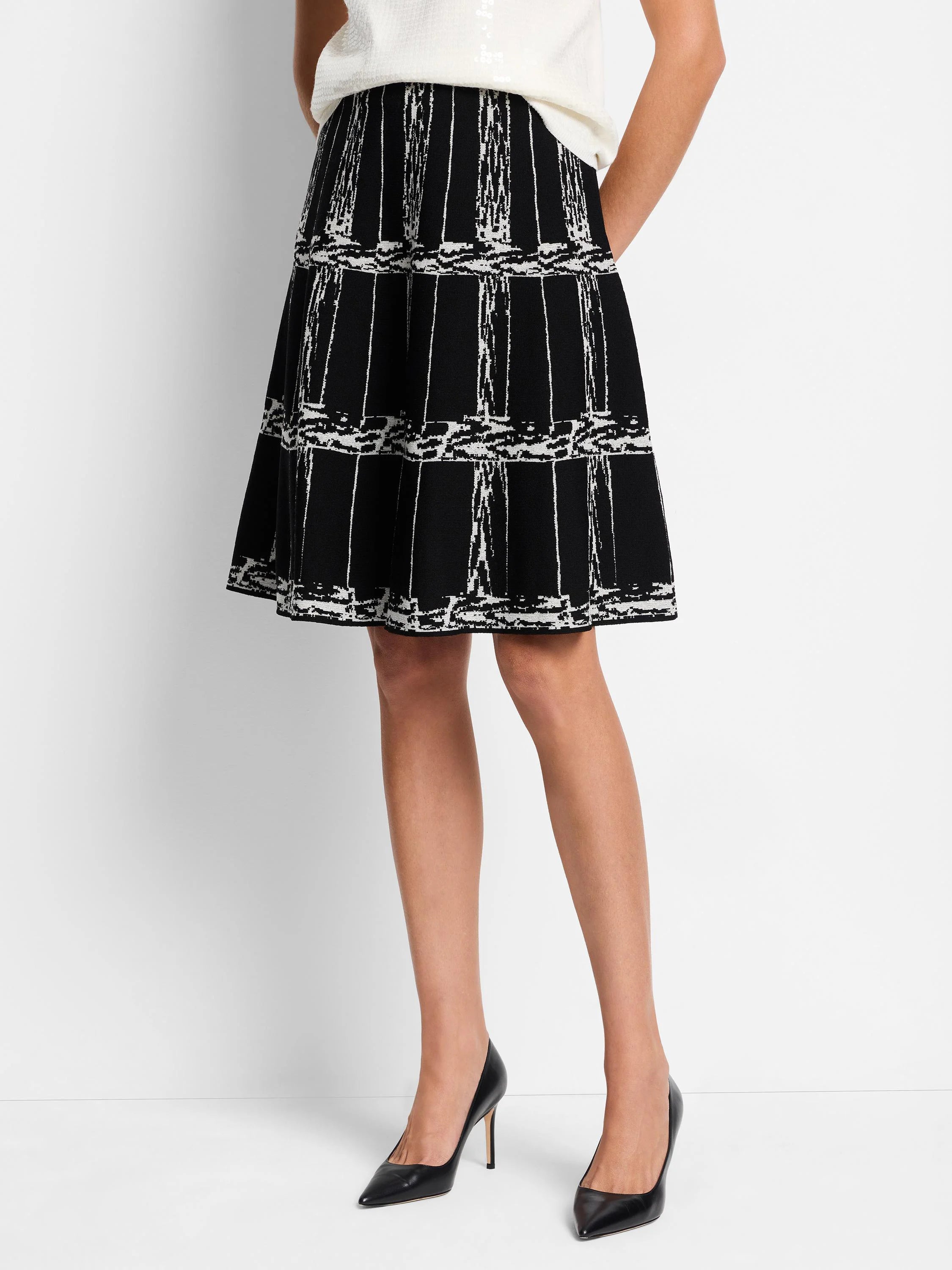 Black A-line skirt with an off-white etched plaid pattern. Knit fabric.