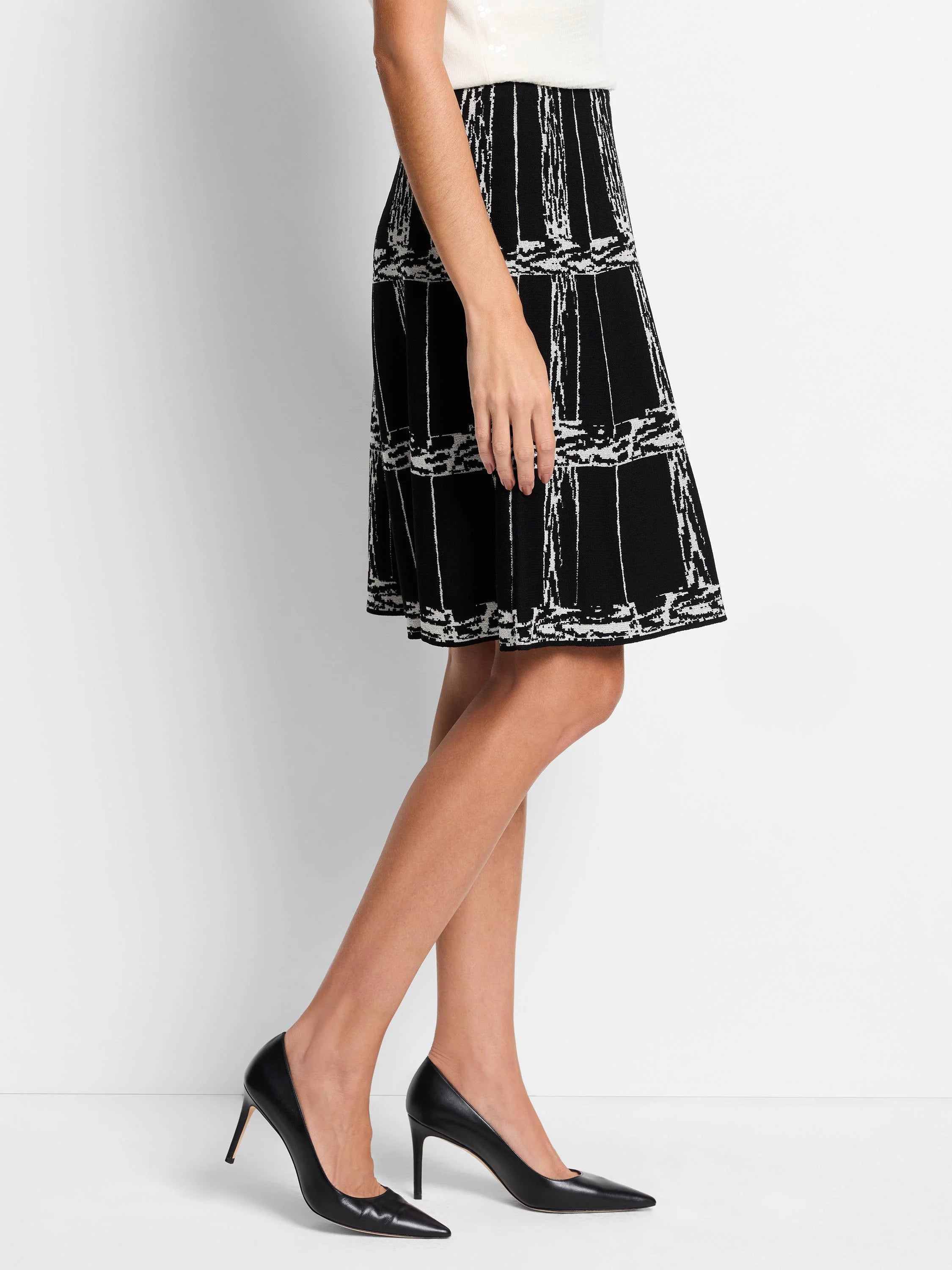 Black A-line knit skirt with an off-white etched plaid pattern.