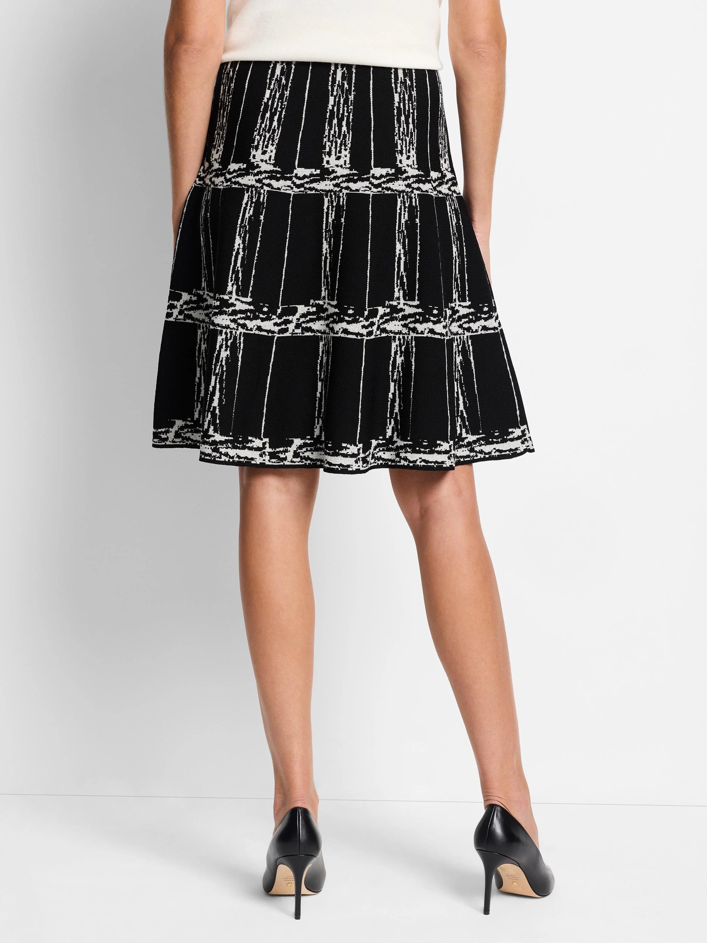 Black A-line knit skirt with an off-white etched plaid pattern.