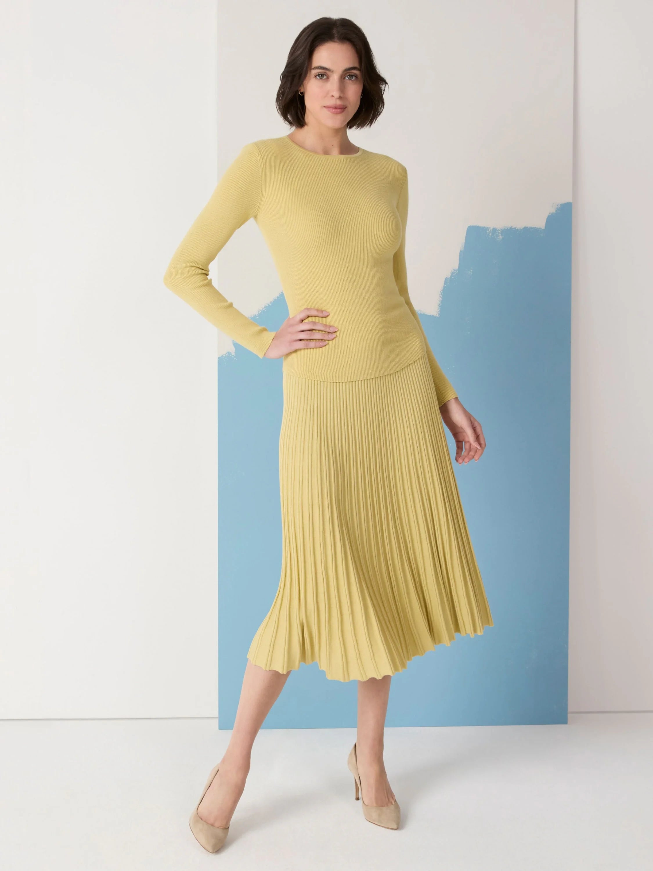 A pale yellow ribbed sweater skirt with visible vertical pleats.