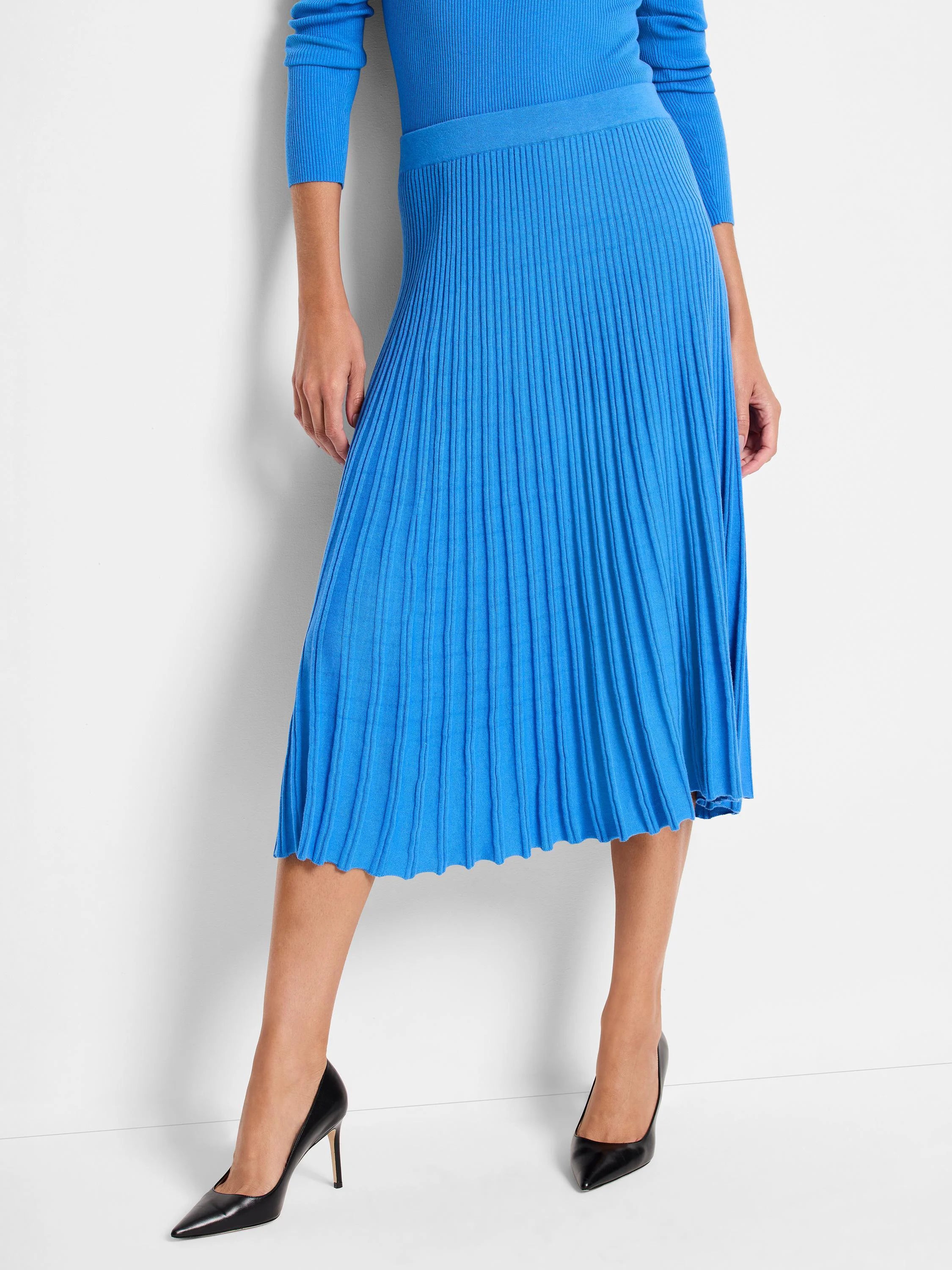 Bright blue ribbed midi skirt with distinct vertical pleating and a wavy hem.