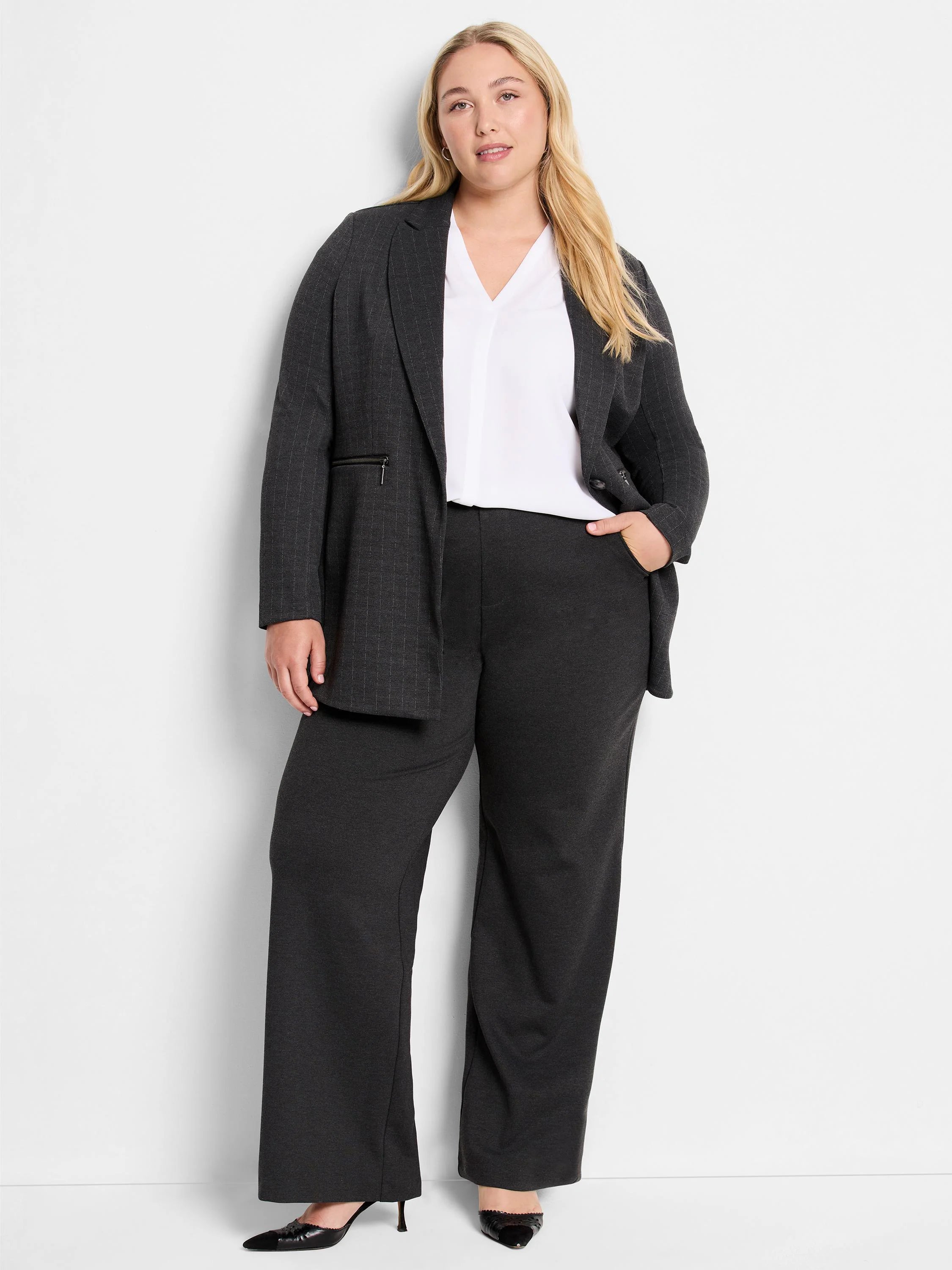 Dark gray wide-leg pants; knit fabric; model shown wearing them with a blazer and white top.