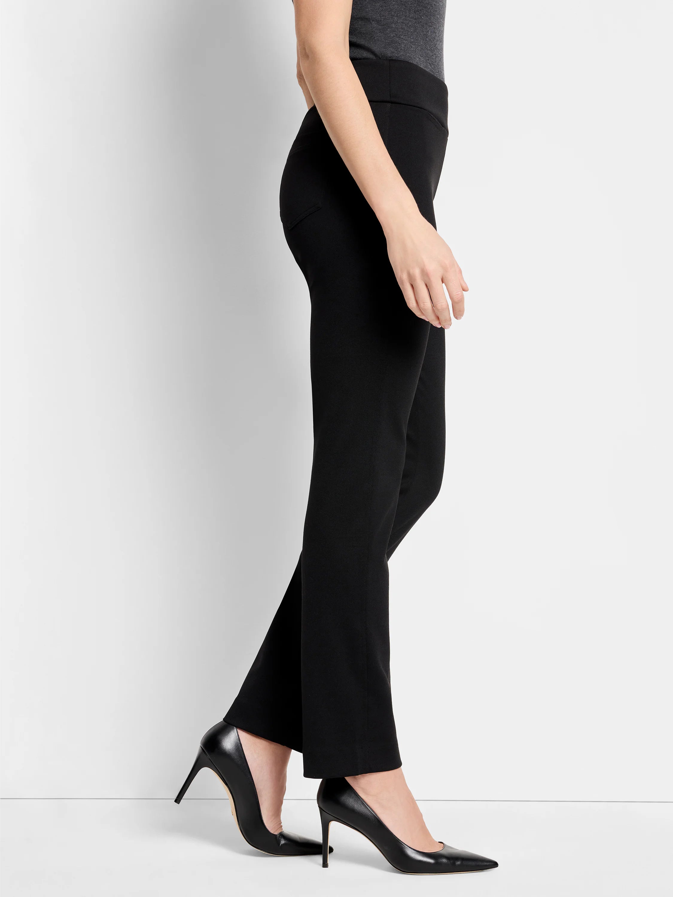 Black knit pants on a model. Features a smooth, wide waistband, subtle side pockets, and a straight leg.