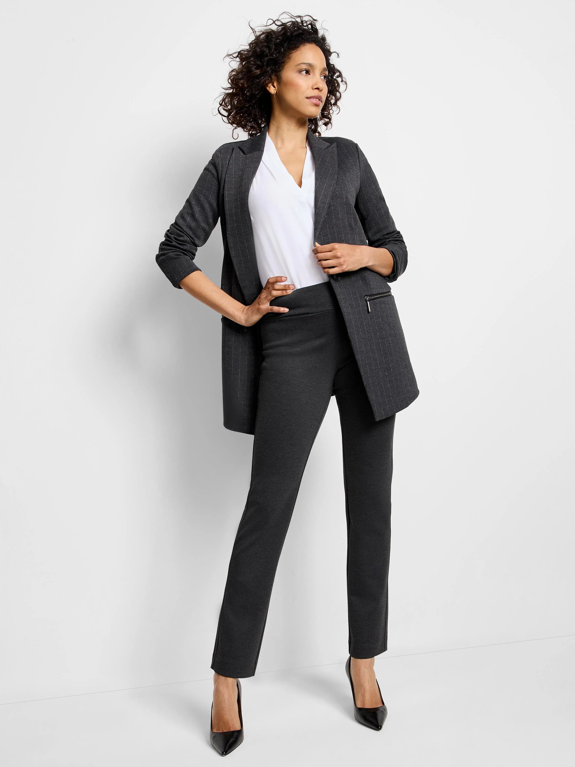 Dark charcoal knit pants with a smooth, wide pull-on waistband and a slim leg. Pockets are subtle.