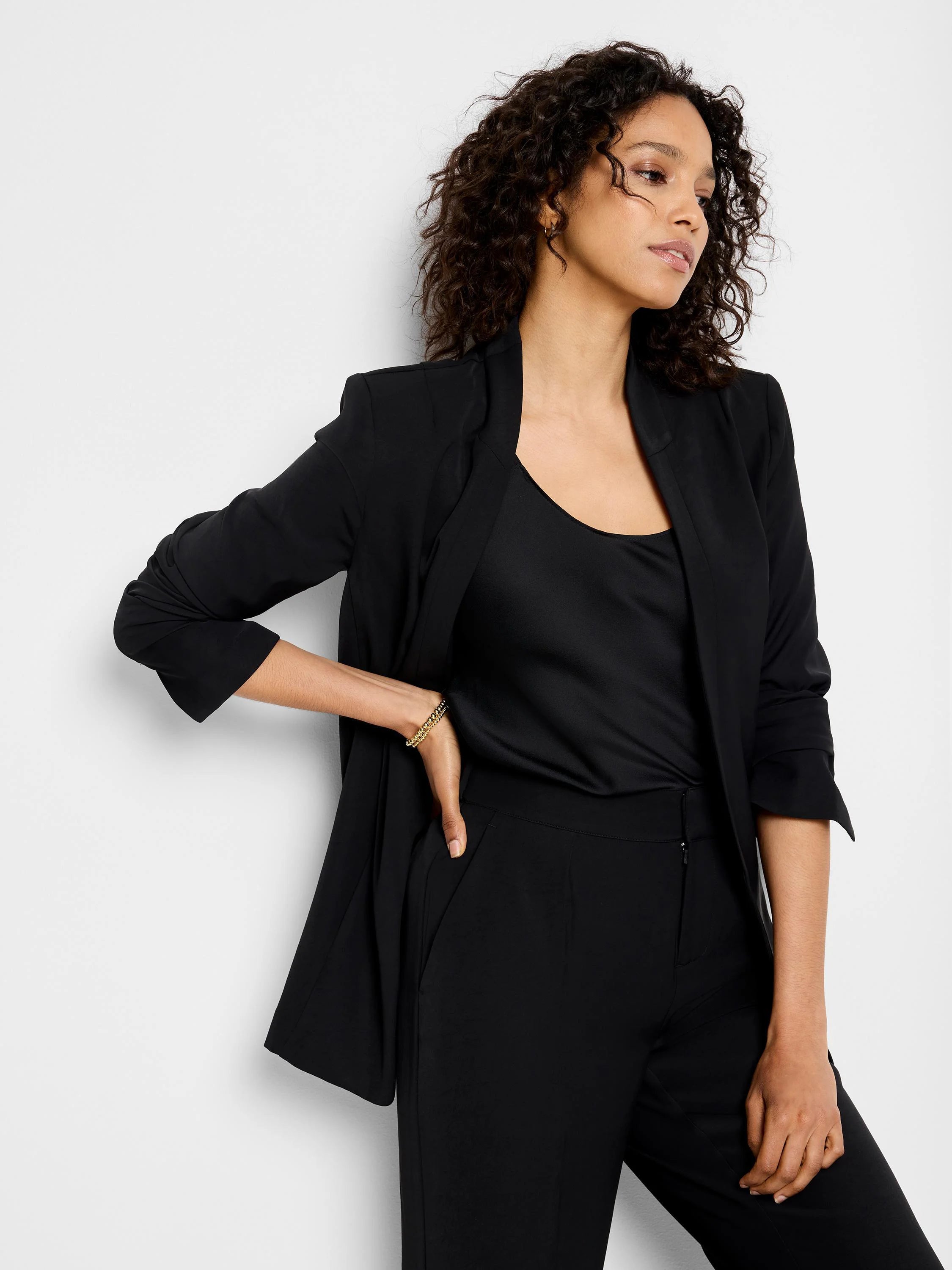 Black blazer, open front, three-quarter sleeves. Model also wears black top and pants.