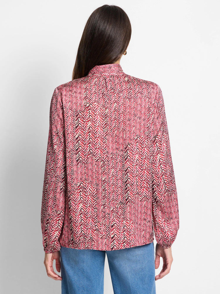 Red and cream herringbone patterned long-sleeve blouse; back view.