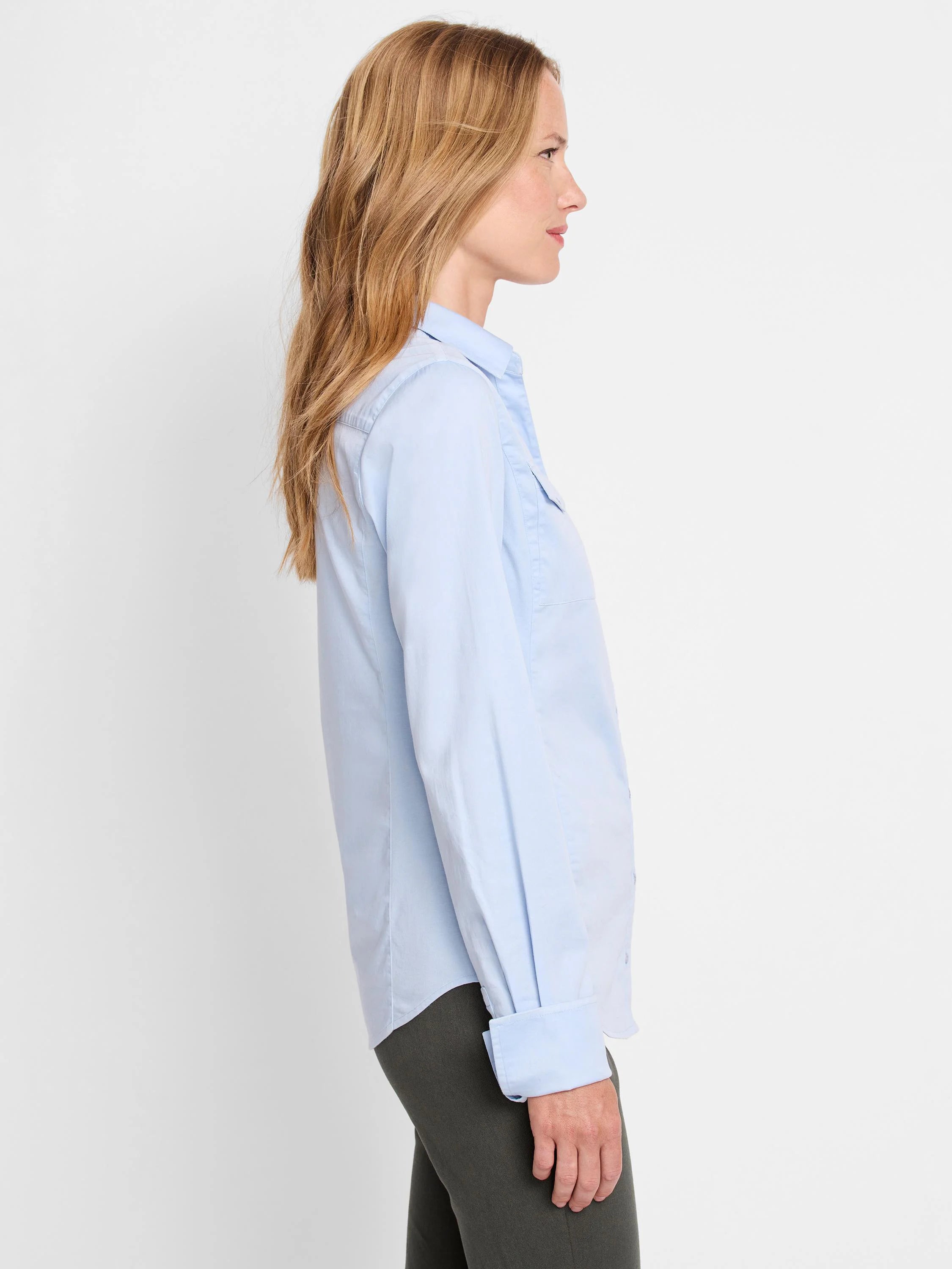 Light blue, long-sleeve button-down shirt; cuffs visible. Side profile view.