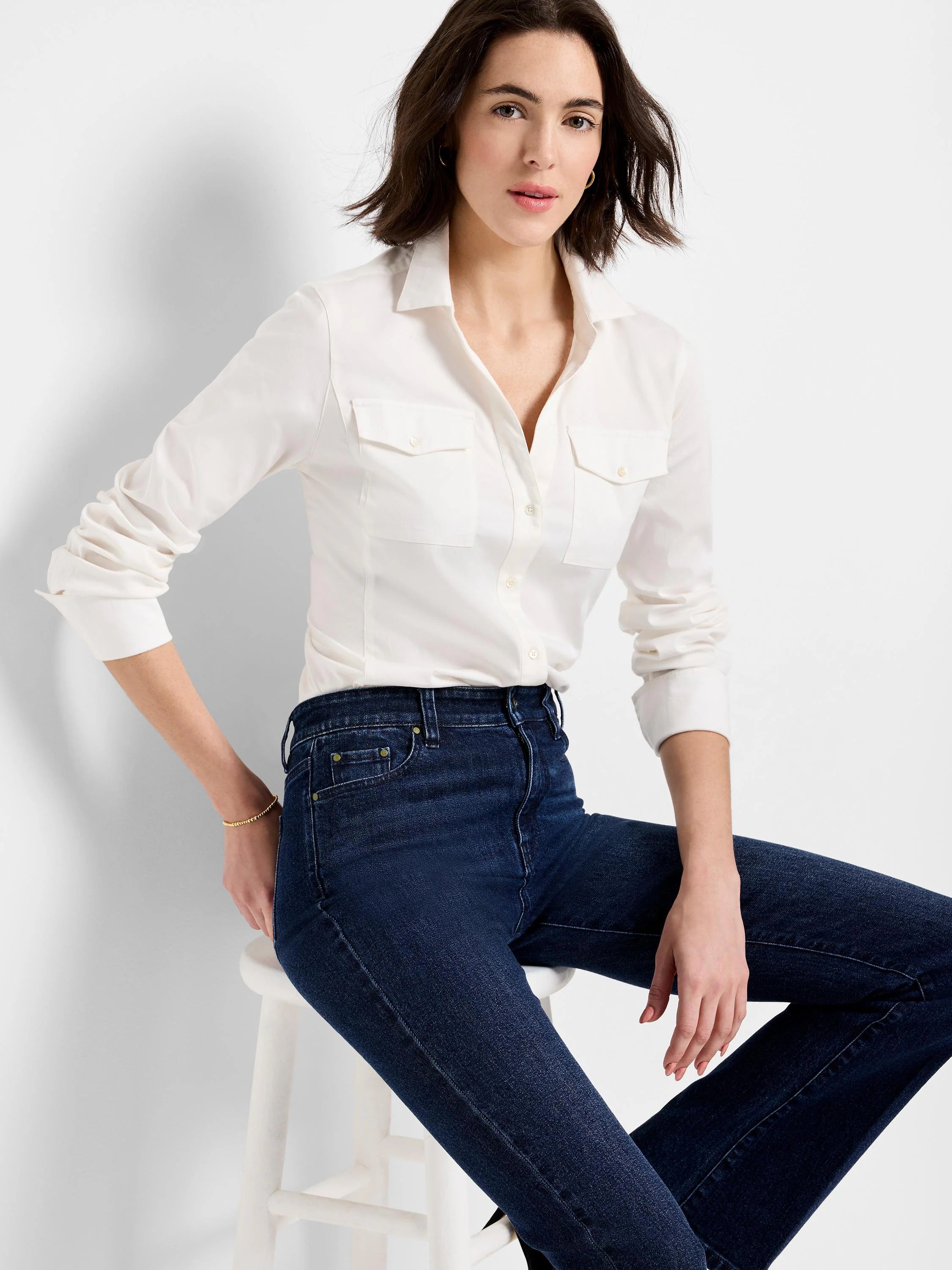 Off-white long-sleeve shirt with two chest pockets, button front. Model is wearing dark wash jeans.