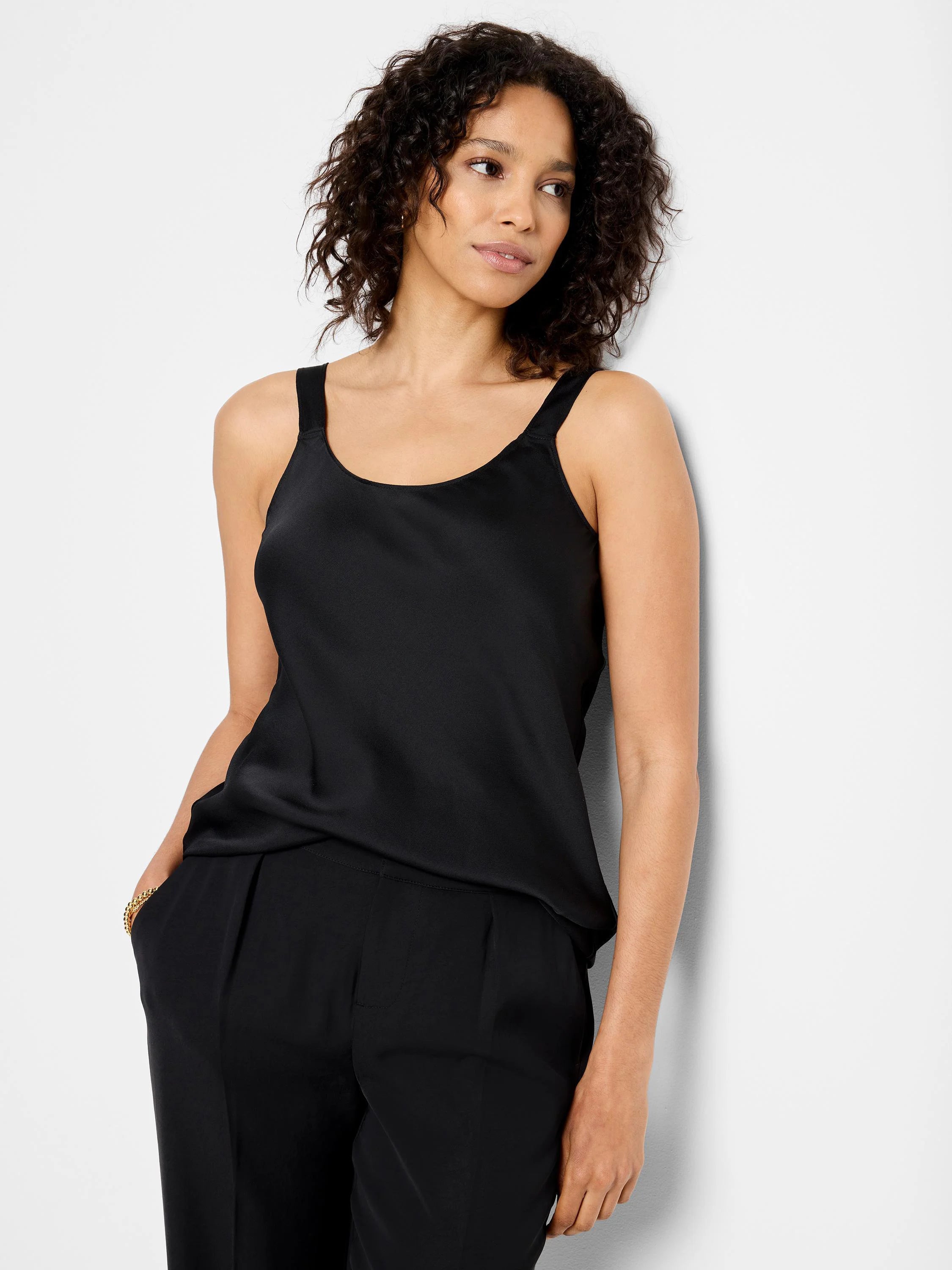 Black crepe cami, scoop neck, thin straps. Model wears matching black pants.