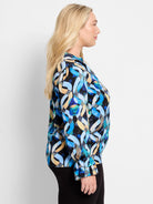 Blue, black, and beige abstract wave pattern long-sleeve top with ruffled cuffs.