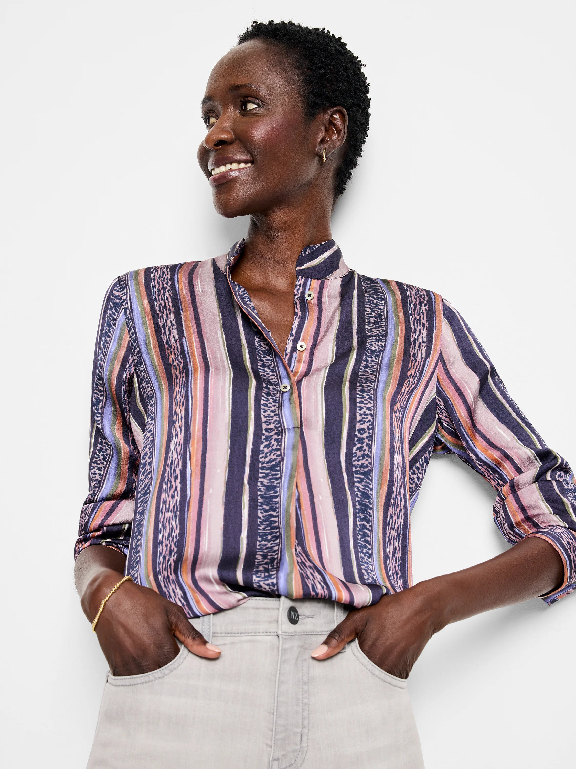 Animal print and multicolored vertical stripes on a long-sleeved collared shirt. Predominantly dark purple, pink, and...