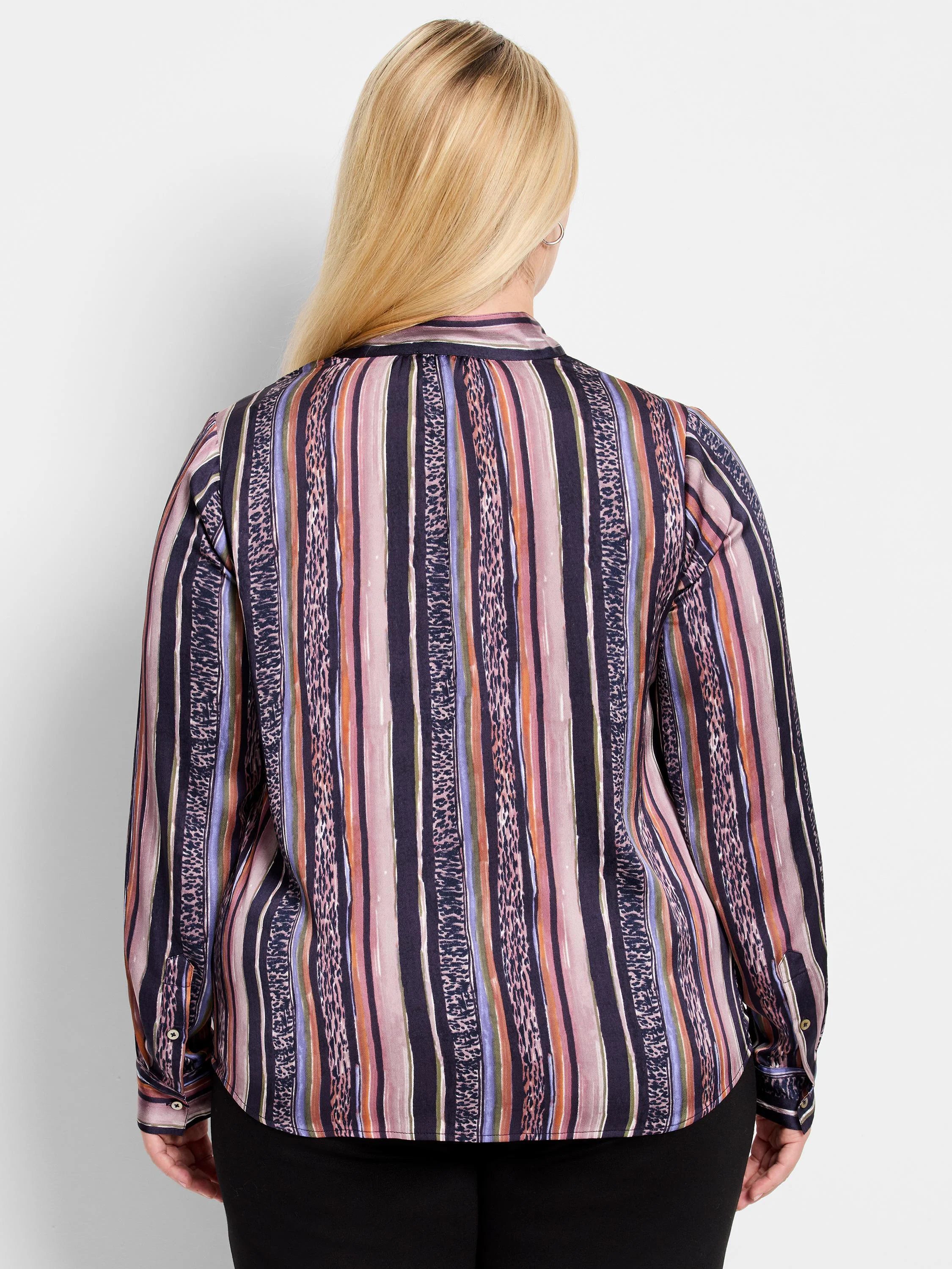 Purple, pink, orange, and green vertical stripes with a subtle animal print. Long sleeves, button cuffs.