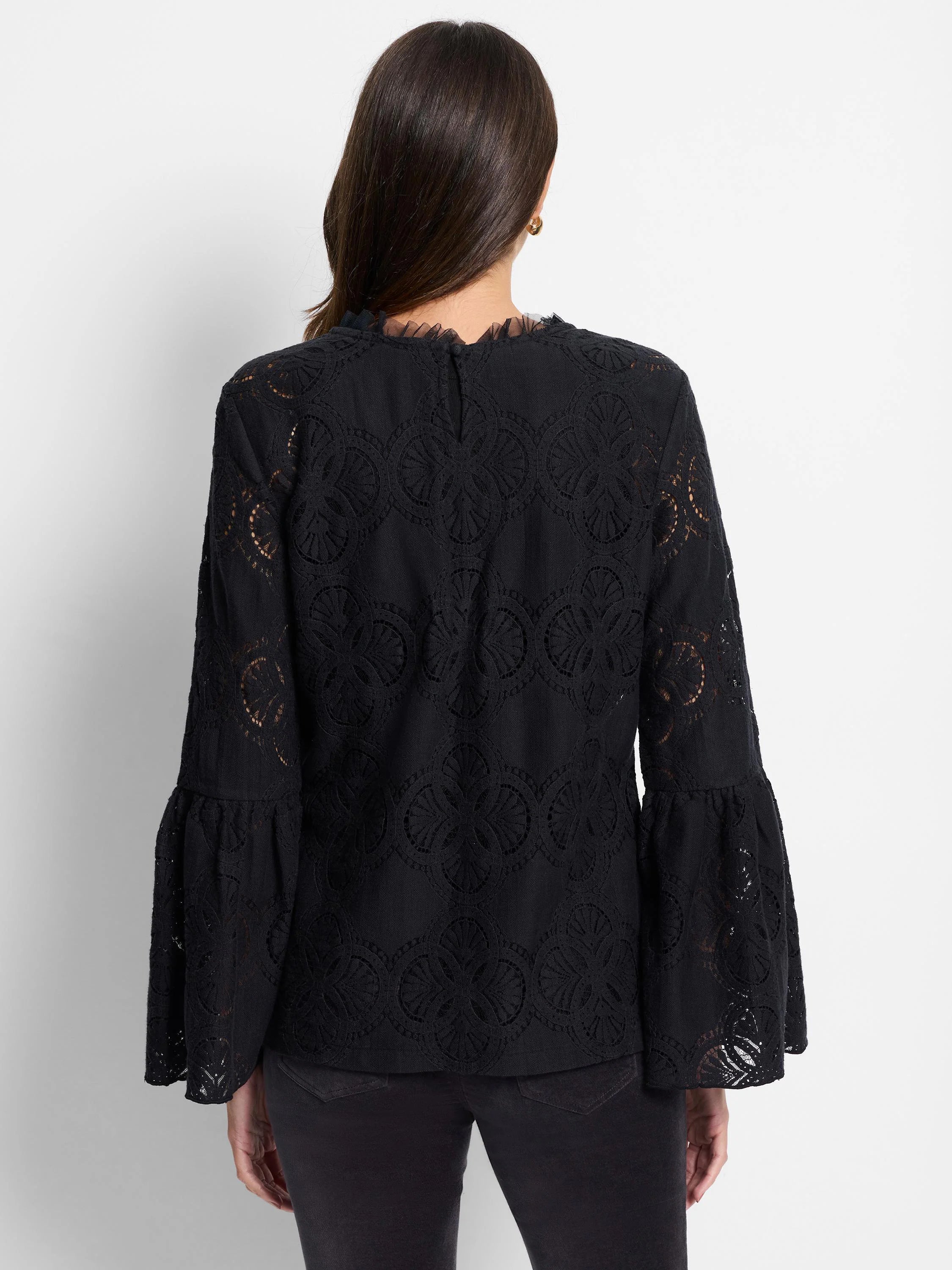 Black lace top with bell sleeves. Intricate circular pattern throughout. Sheer fabric.