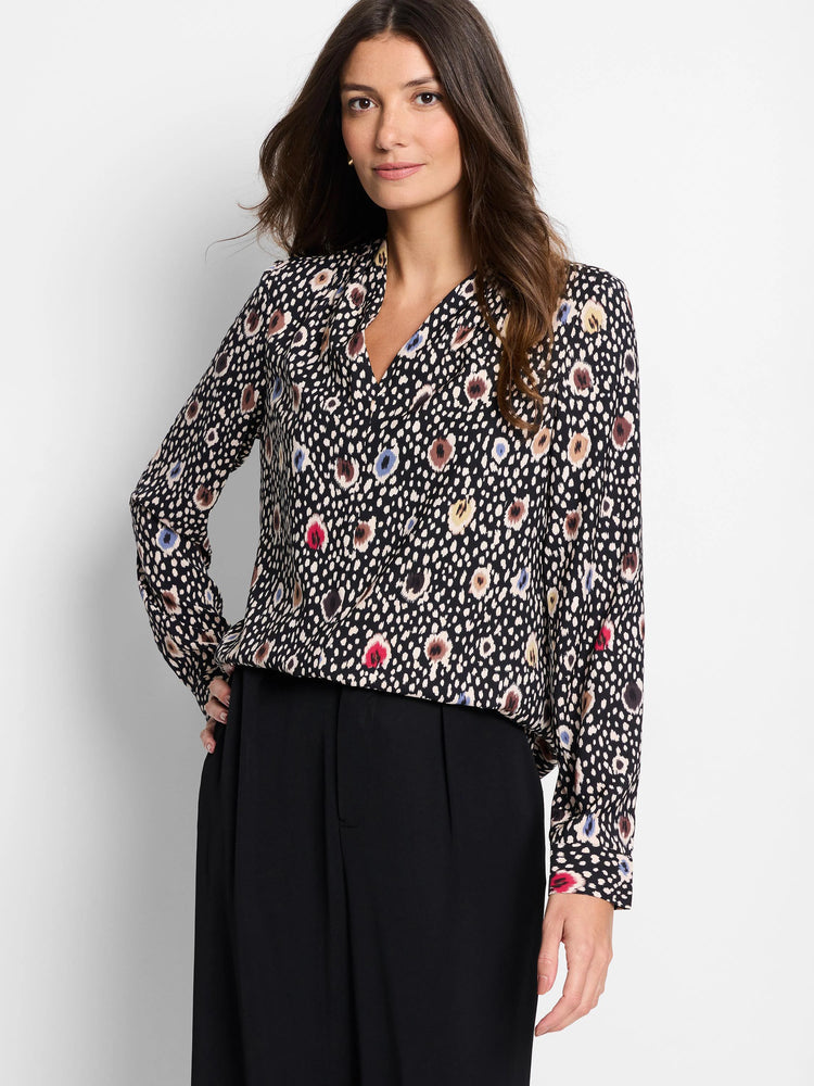 Black long-sleeved blouse. Multicolored spotted pattern: beige, brown, red, blue. V-neck.