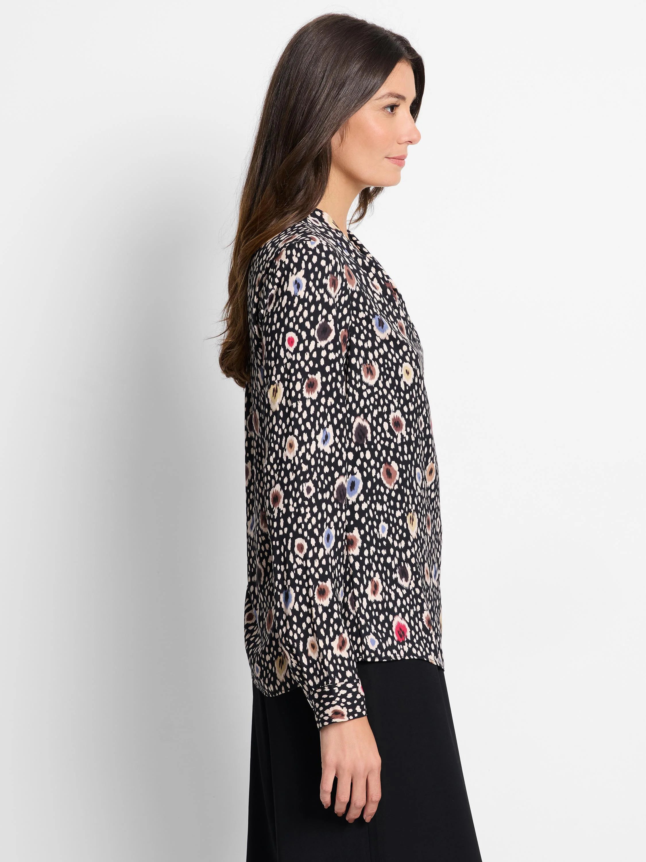 Black long-sleeve top with beige, brown, blue, and red spotted pattern.