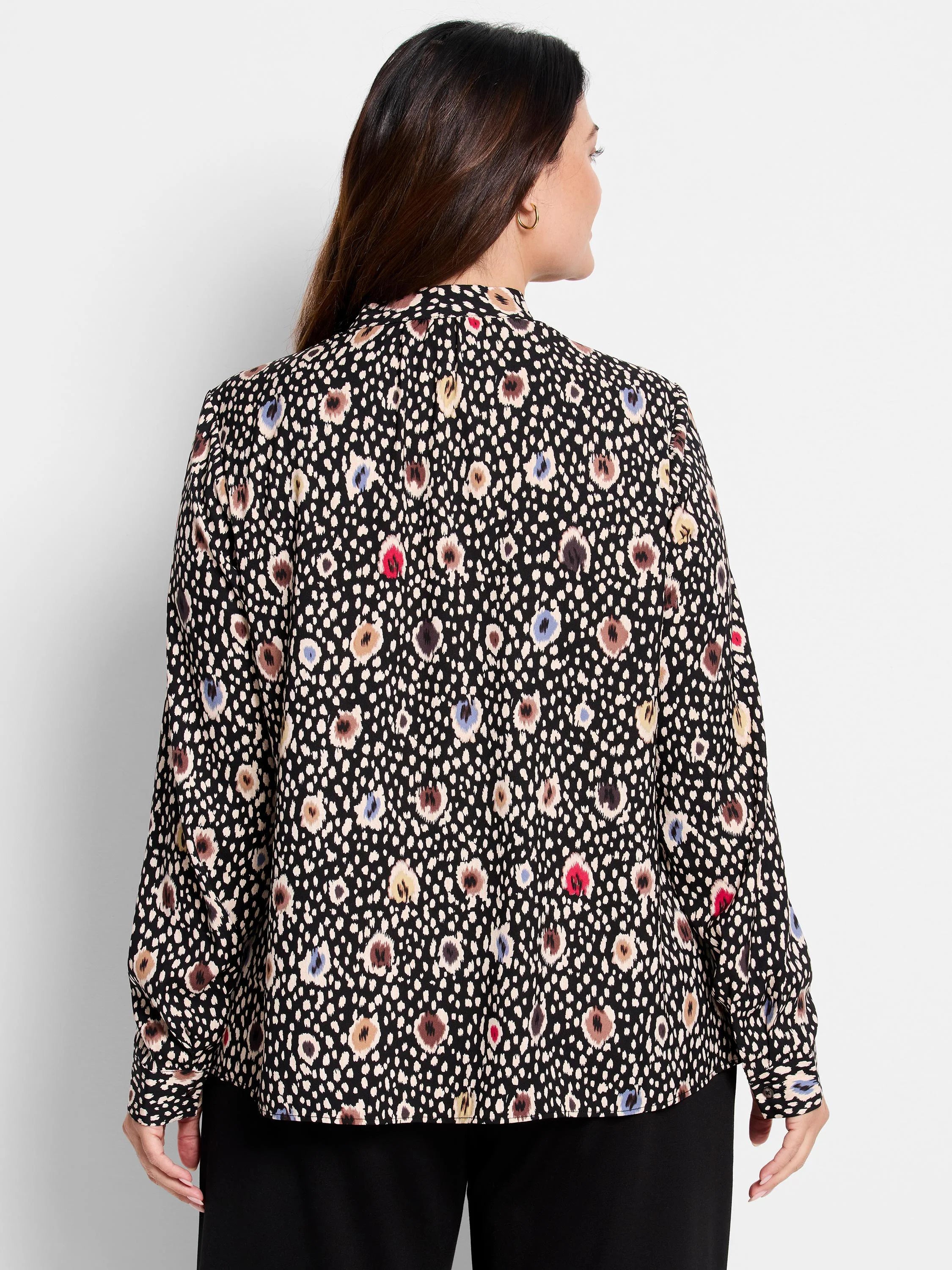 Black long-sleeve blouse. Features a multicolored spotted pattern in beige, brown, red, and blue on a black background. ...