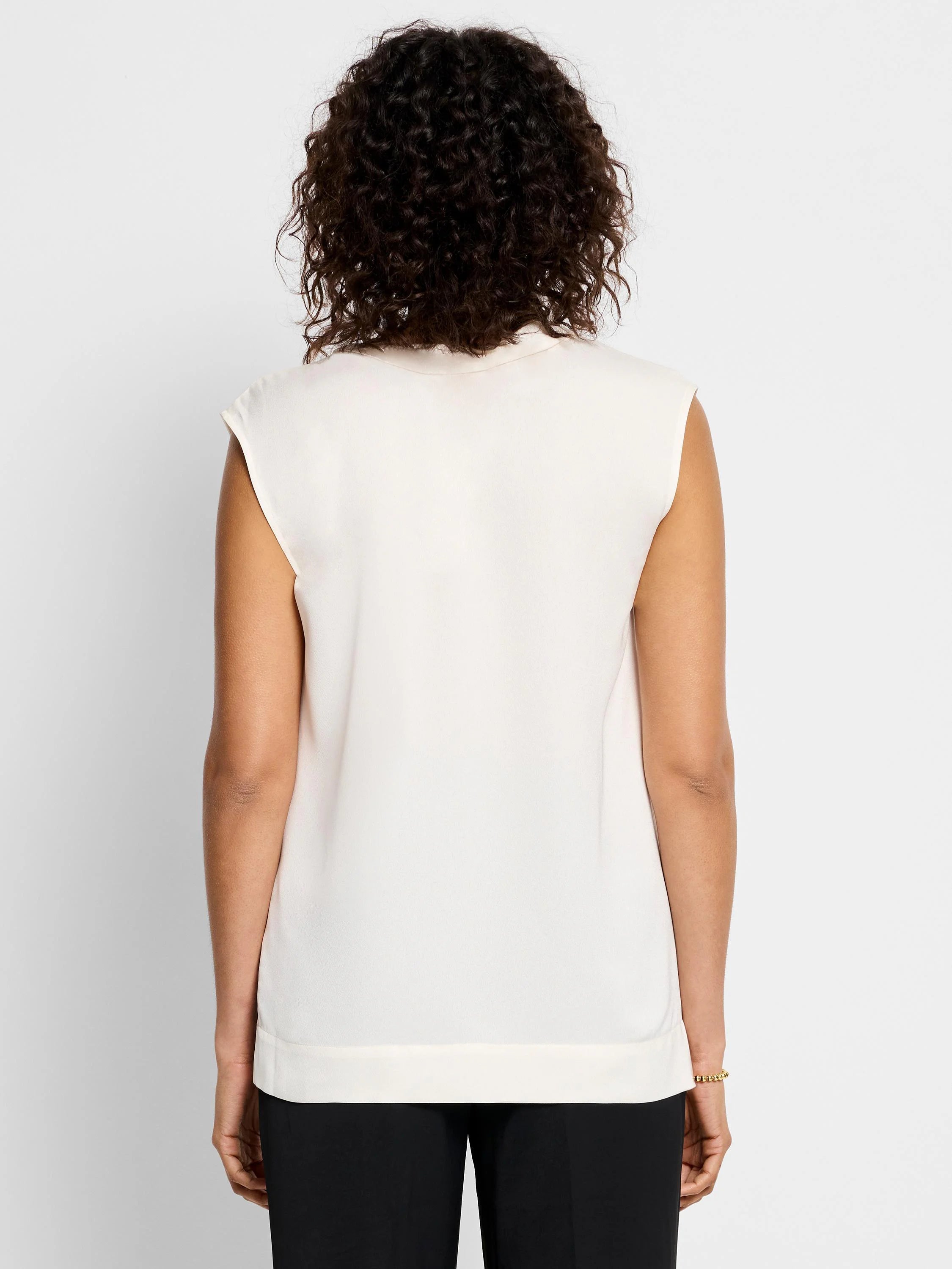 Off-white sleeveless satin jacket;  straight hem.  Rear view.