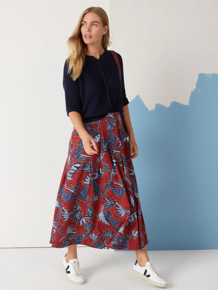 Red midi-length skirt with a blue and purple leaf print. A-line shape.