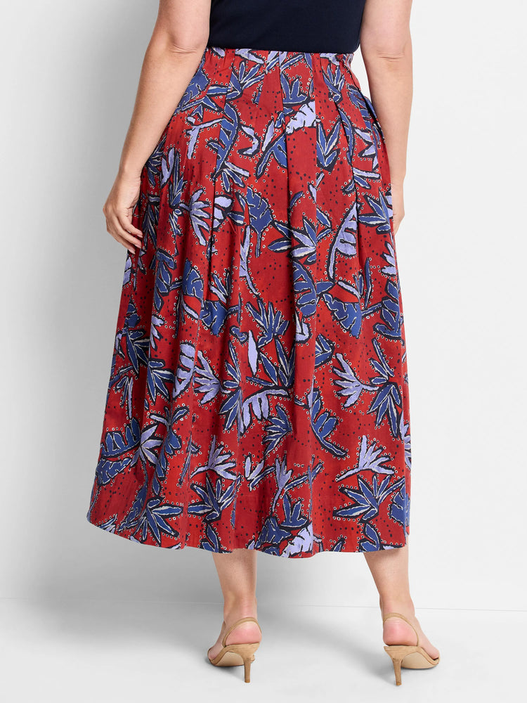 Red midi skirt with pleated detail. Features a blue and purple leaf print on a red background.