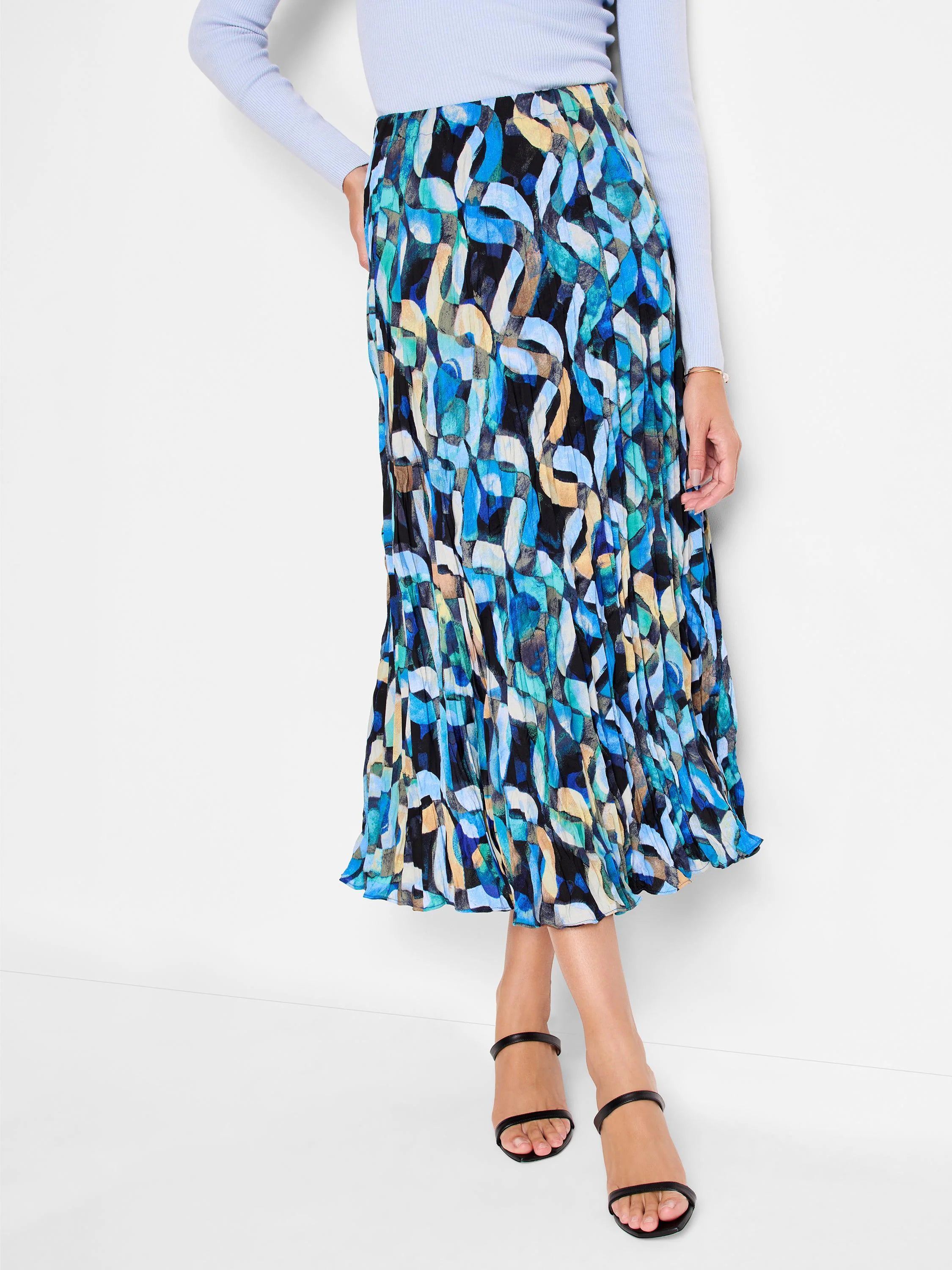 Midi pleated skirt with abstract blue, teal, and beige pattern on black background.