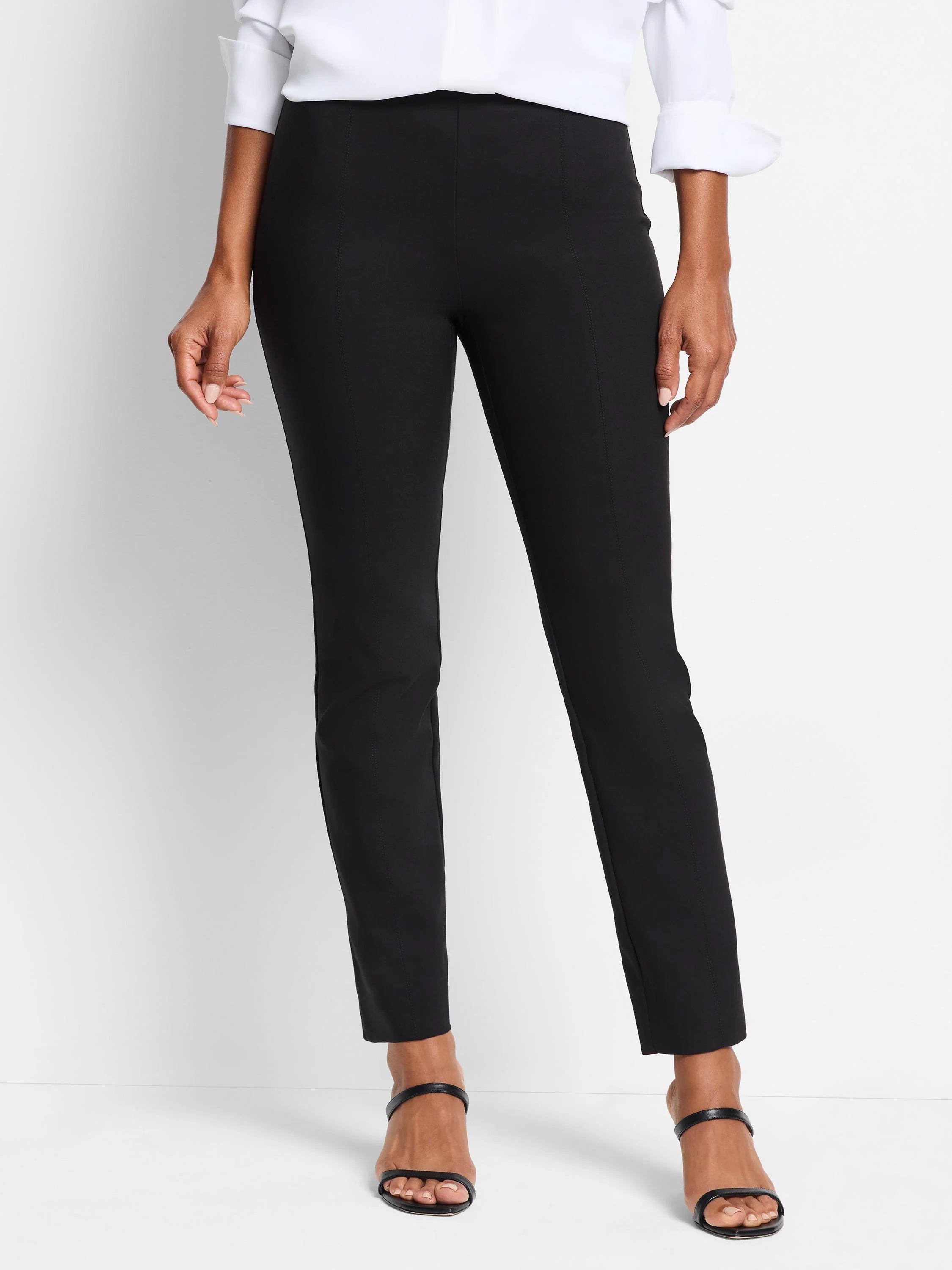 Black slim-cut pull-on pants; straight leg. Center seam detail. Model shown wearing black heels.